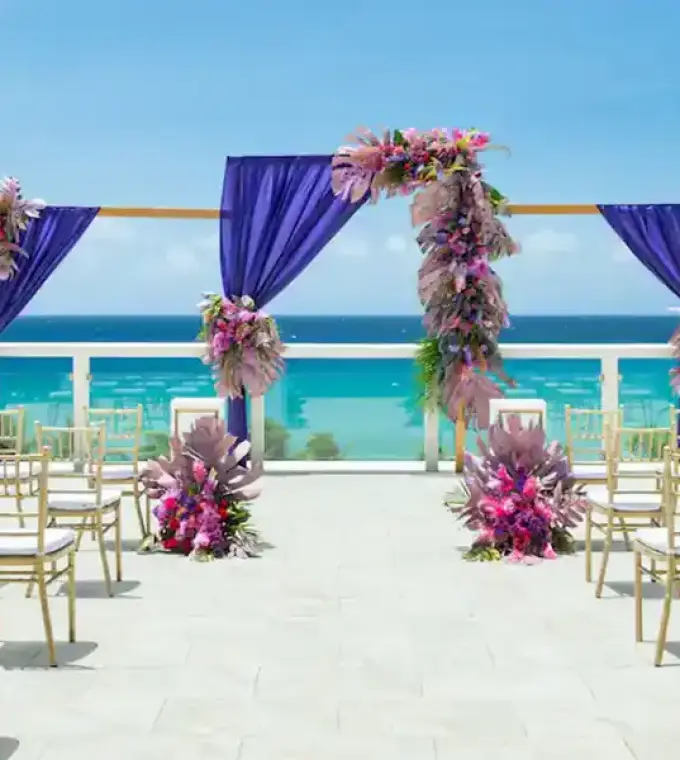 Sky lounge wedding ceremony setup with purple drapes and floral arch at Hyatt Zilara Rose Hall, Montego Bay