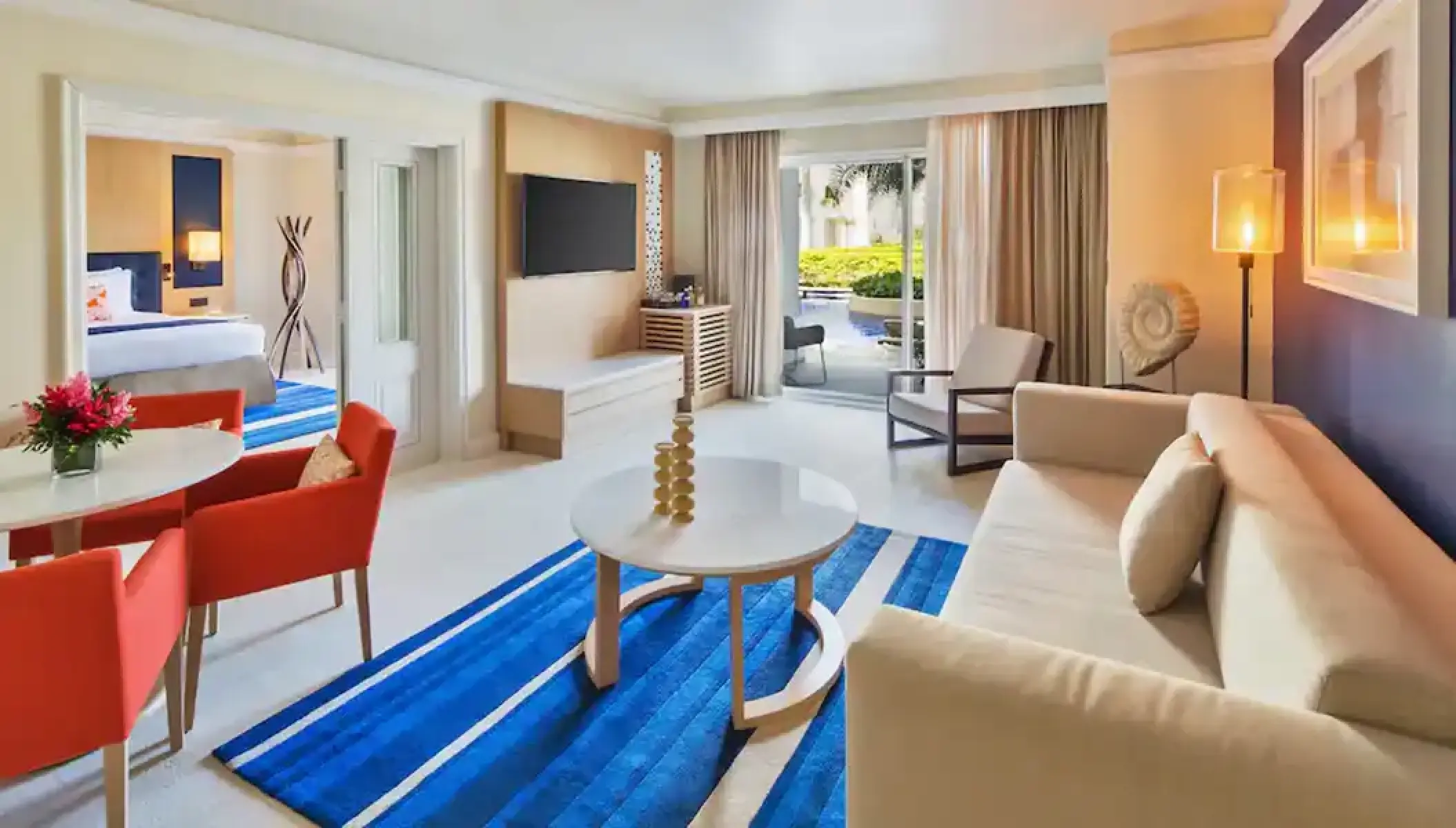 Modern hotel suite living area with blue rug and orange chairs at Hyatt Zilara Rose Hall, Montego Bay