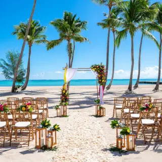 Beachfront wedding ceremony setup with an arch and wooden chairs at Hyatt Ziva Cap Cana, Punta Cana