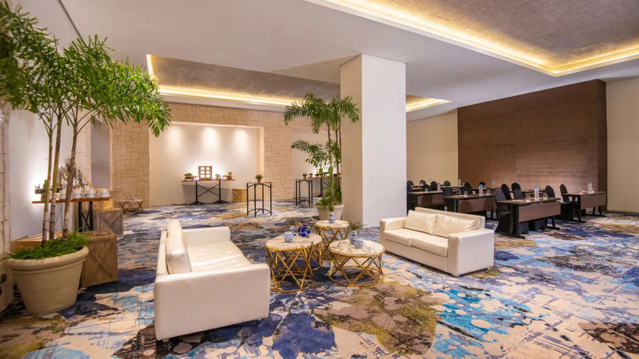 Modern lounge and meeting room with white sofas and blue patterned carpet at Hyatt Ziva Cap Cana, Punta Cana
