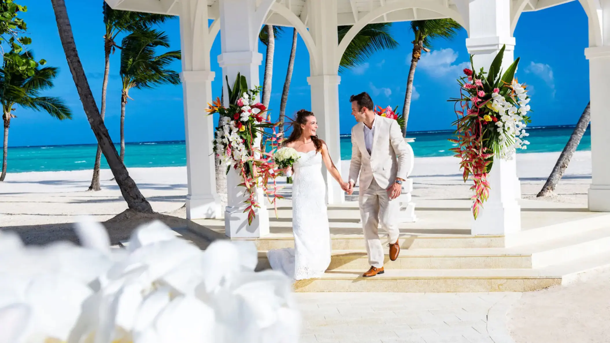 Bride and groom walking out of the beach gazebo at Hyatt Ziva Cap Cana, Punta Cana