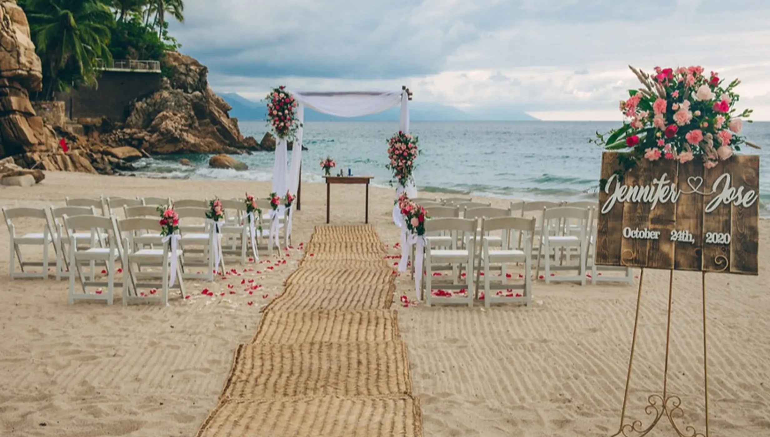Beachfront wedding ceremony setup with Jennifer and Jose welcome sign at Hyatt Ziva Puerto Vallarta