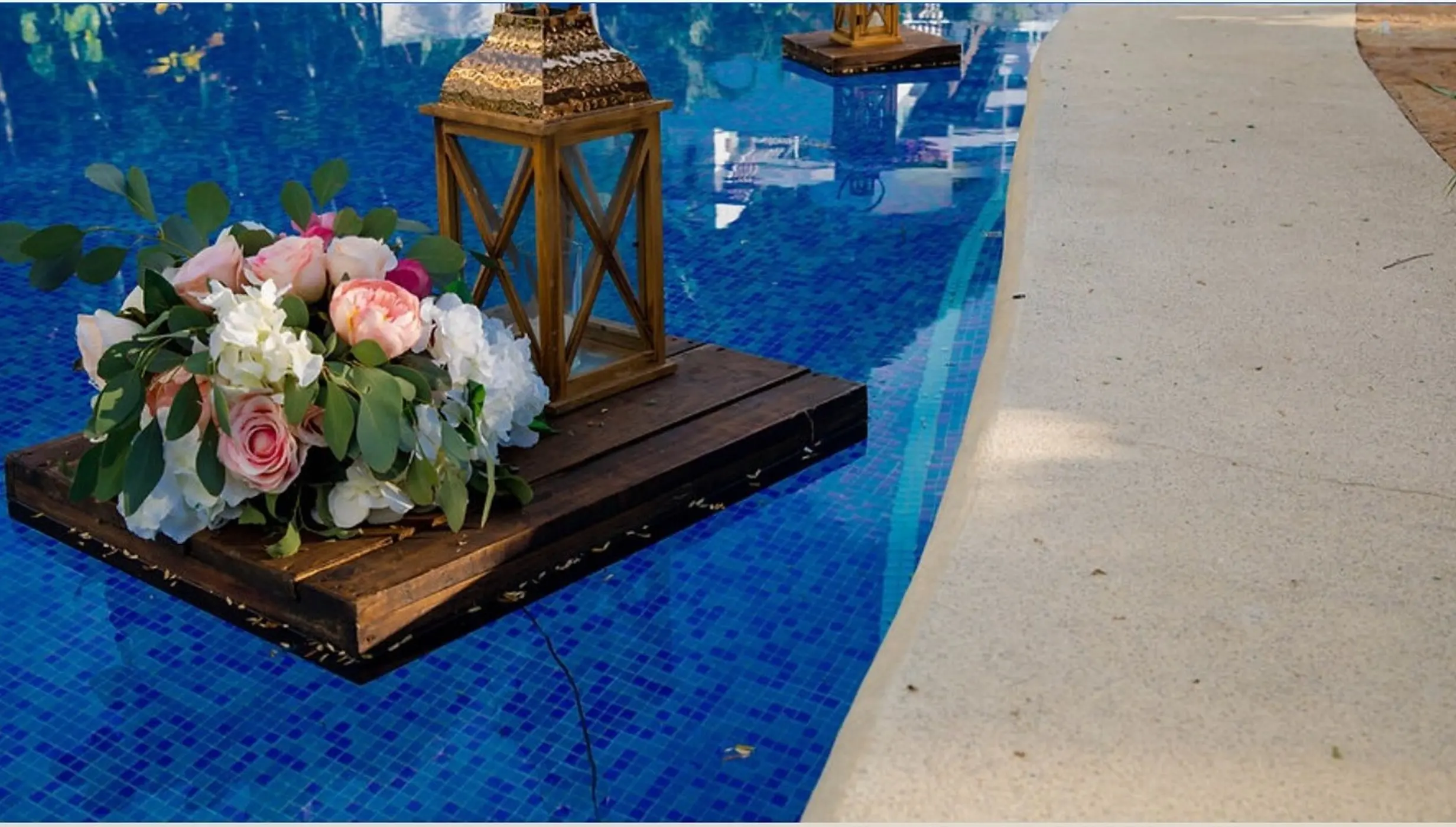 Floral centerpiece and wooden lantern on a floating pool platform at Hyatt Ziva Puerto Vallarta