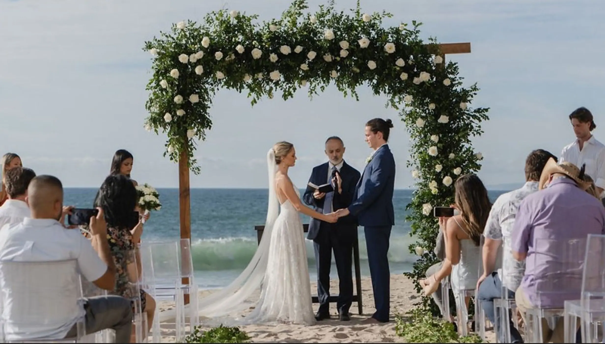 Beachfront wedding ceremony under a white rose arch at Hyatt Ziva Puerto Vallarta