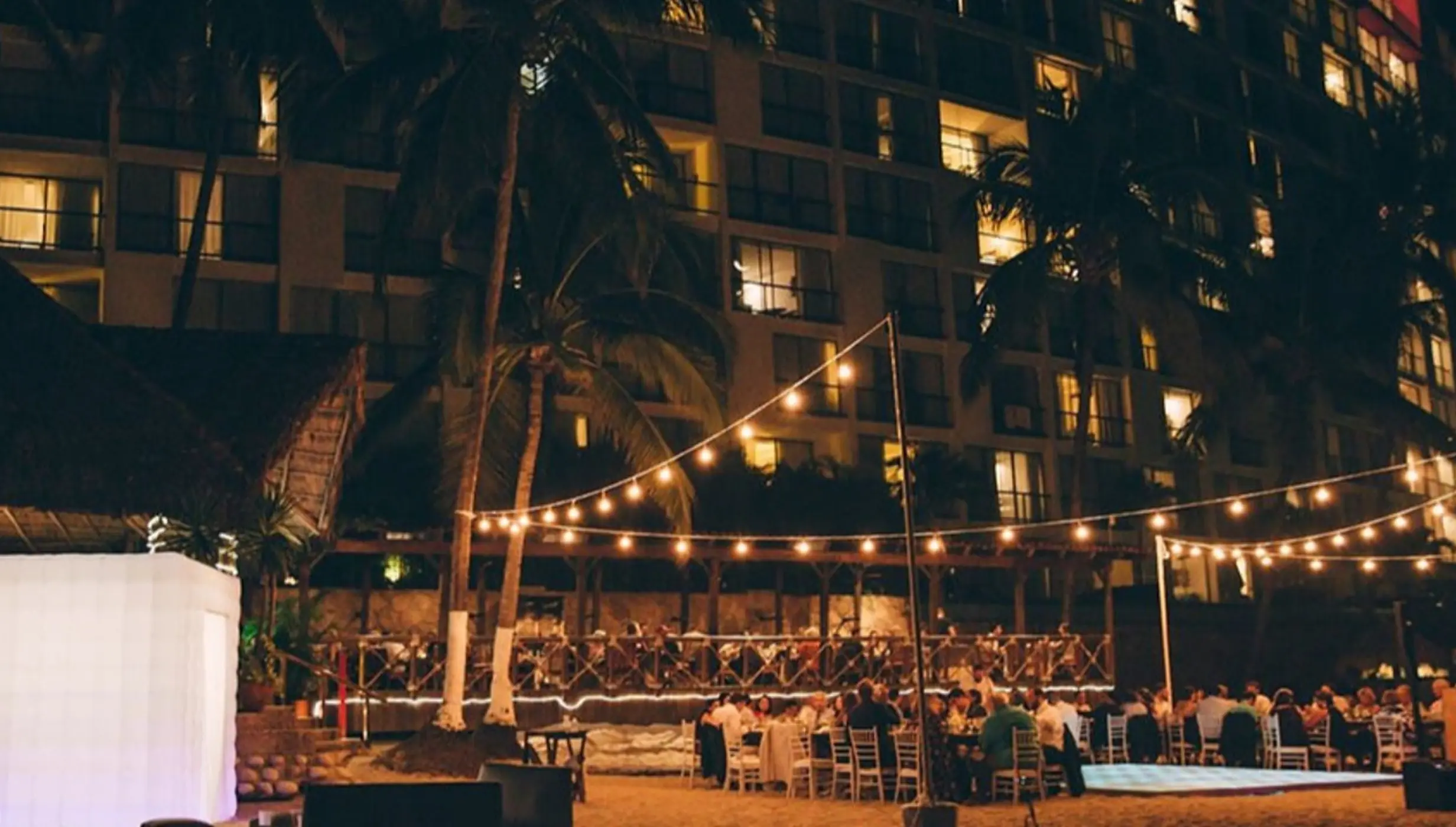 Evening wedding reception under string lights on the beach at Hyatt Ziva Puerto Vallarta