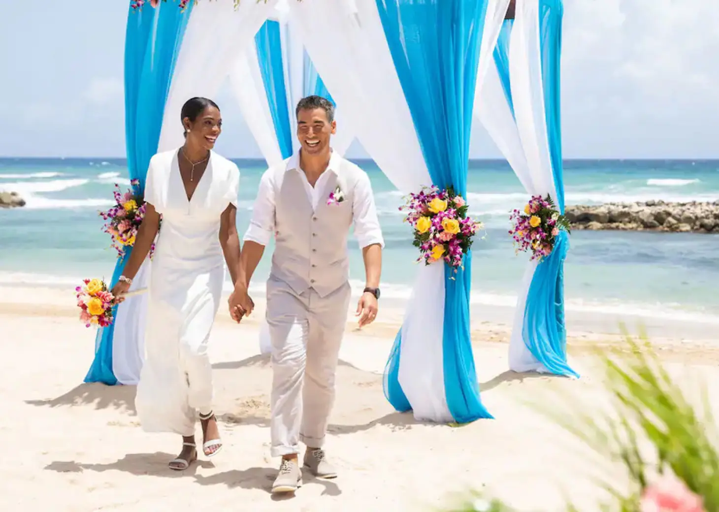 Bride and groom walking from a beach ceremony at Hyatt Ziva Rose Hall, Montego Bay