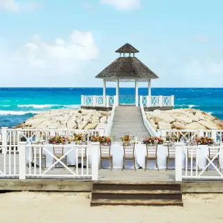 Oceanfront wedding reception setup on a terrace with a gazebo at Hyatt Ziva Rose Hall, Montego Bay