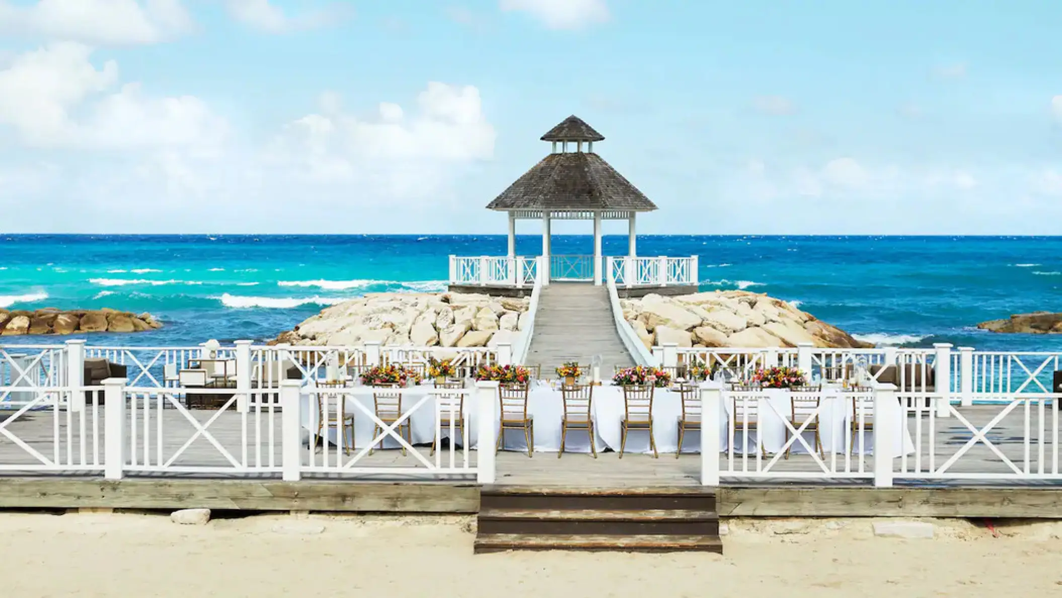 Oceanfront wedding reception setup on a terrace with a gazebo at Hyatt Ziva Rose Hall, Montego Bay