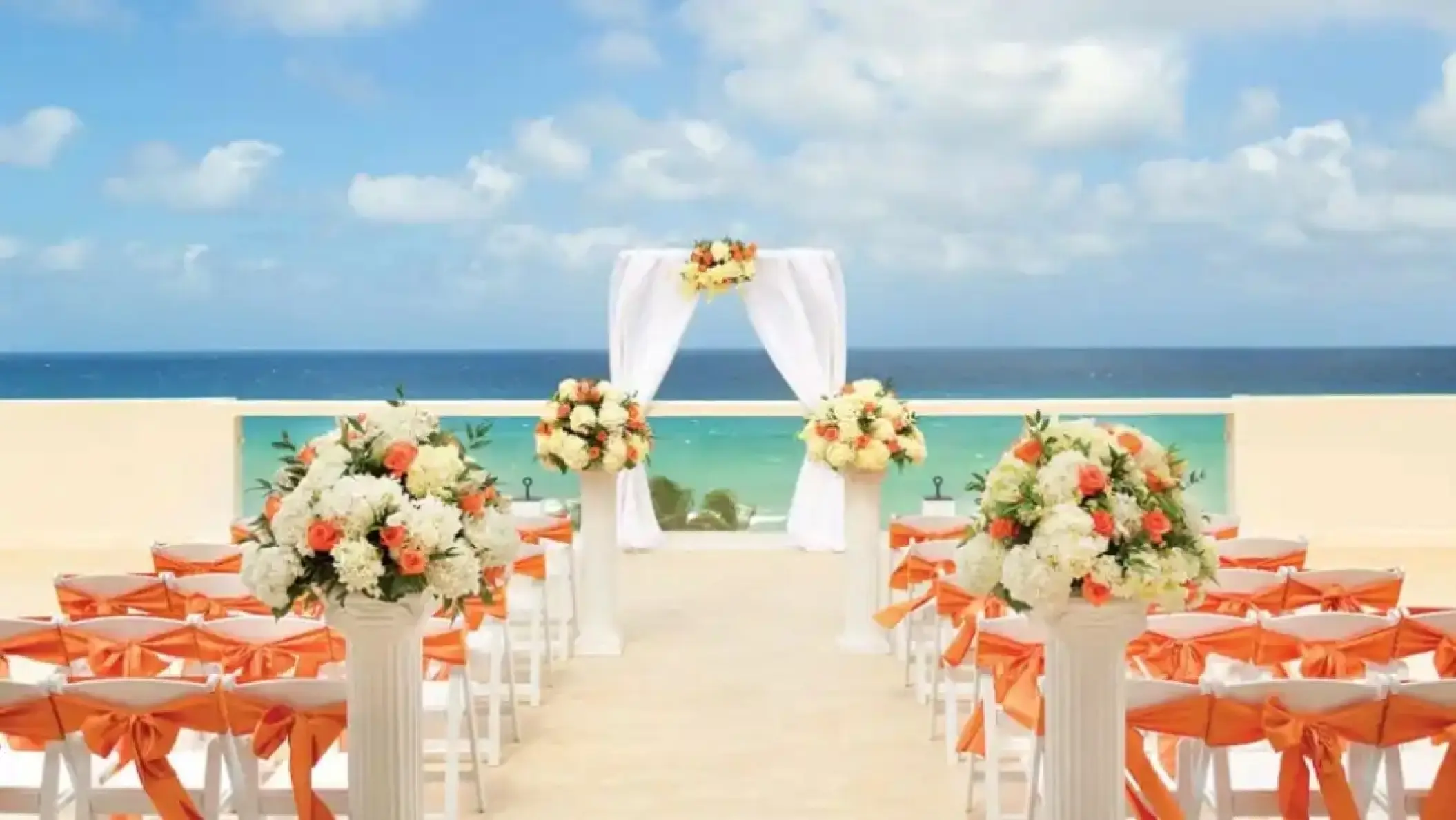 Sky Lounge wedding ceremony with orange floral arrangements at Hyatt Ziva Rose Hall, Montego Bay