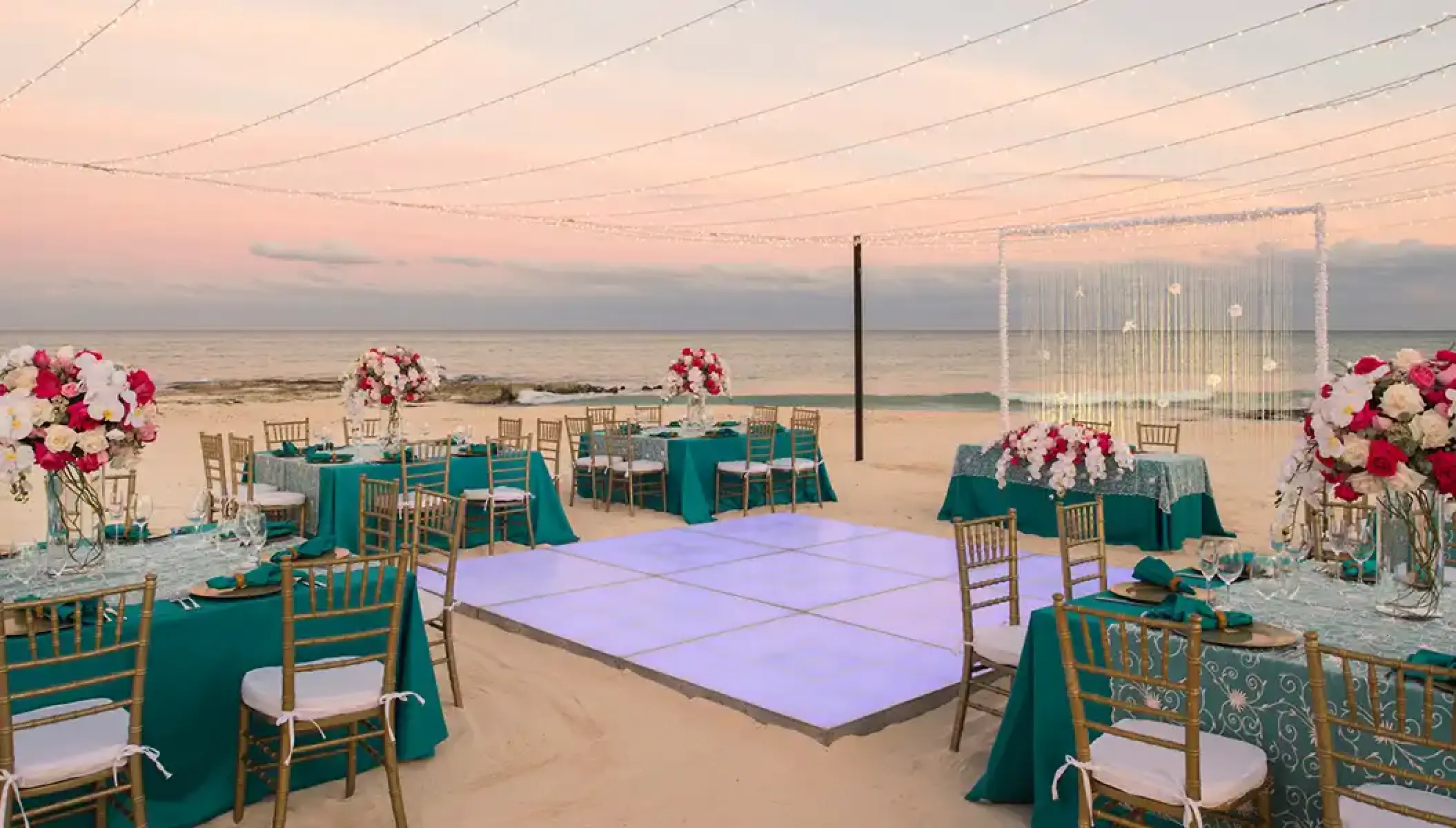 Beachfront wedding reception at JOIA Paraiso by Iberostar featuring a dance floor and turquoise linens in Riviera Maya
