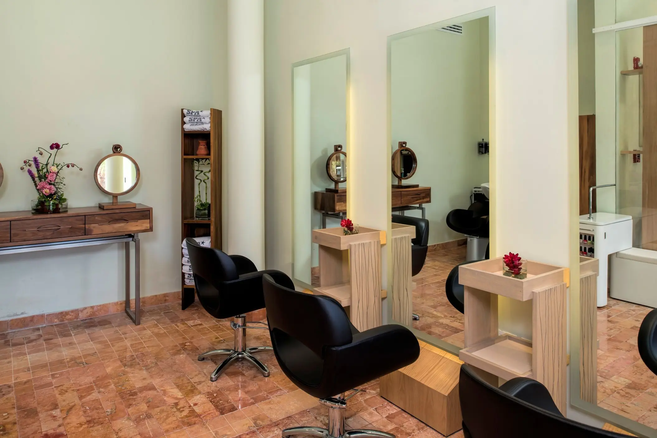 Hair salon with black styling chairs and tall mirrors at Iberostar Waves Tucan, Playa Del Carmen