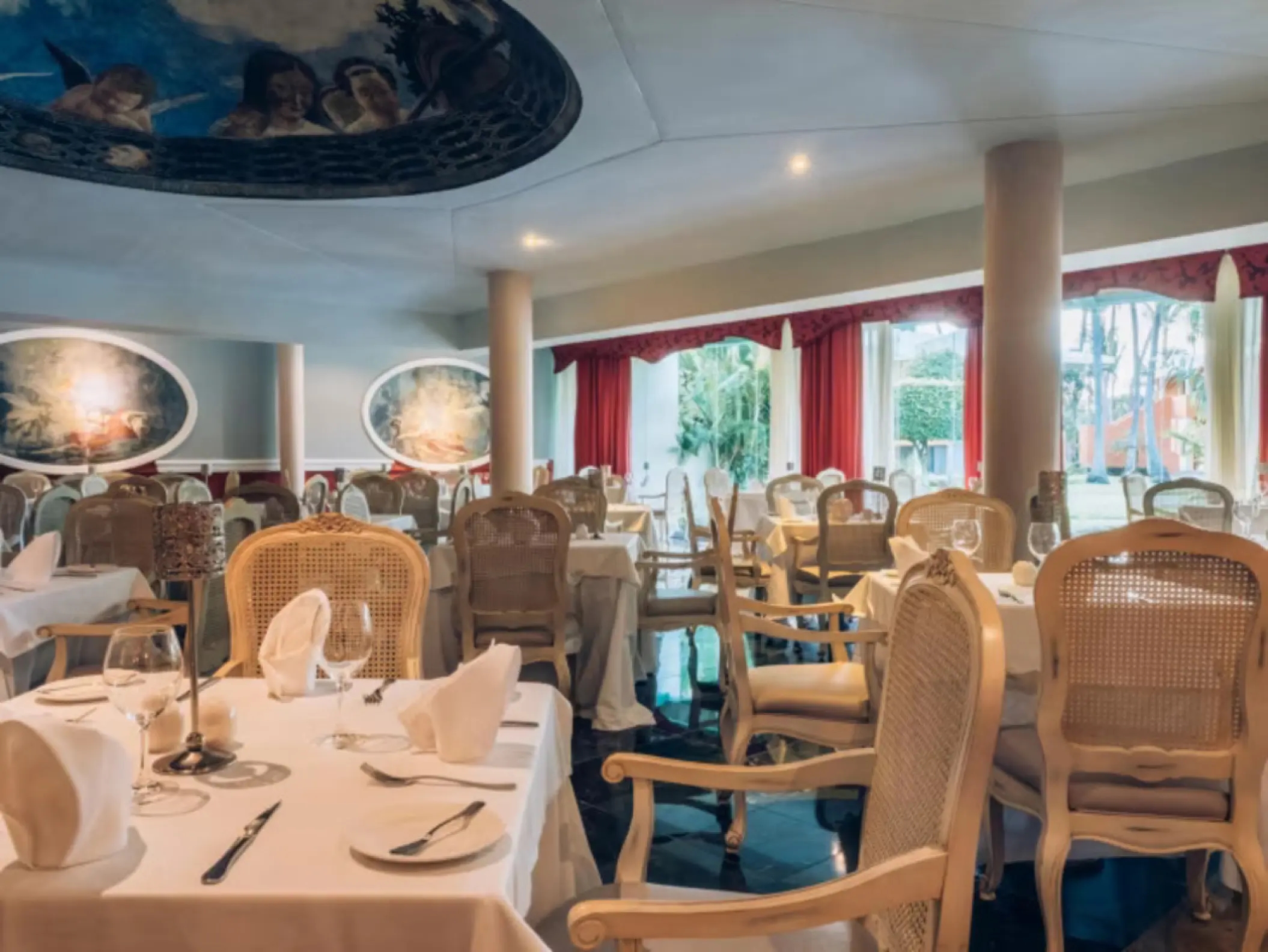 Italian restaurant with mural ceilings and white table linens at Iberostar Selection Bavaro, Punta Cana