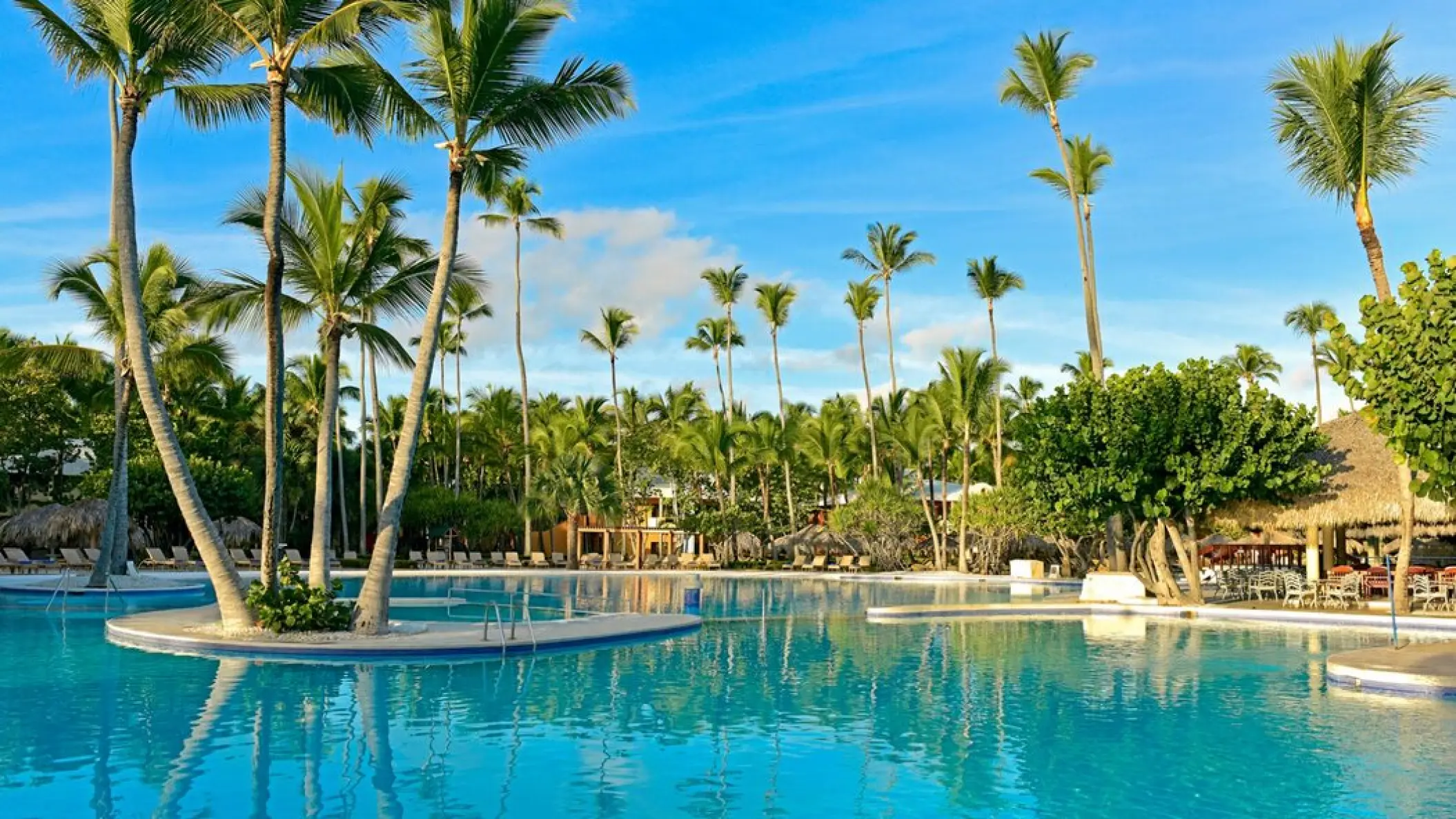 Palm trees surrounding a large outdoor swimming pool at Iberostar Selection Bavaro, Punta Cana