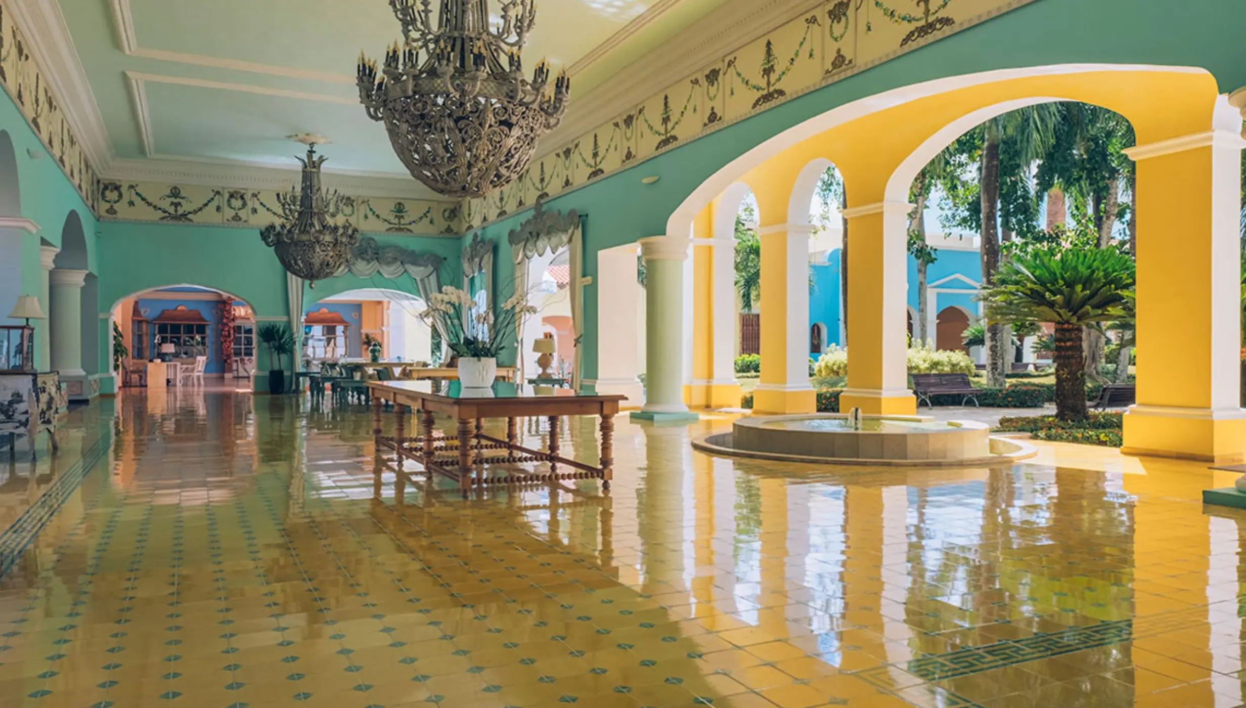 Colonial-style lobby with chandeliers and yellow arches at Iberostar Selection Hacienda Dominicus, La Romana