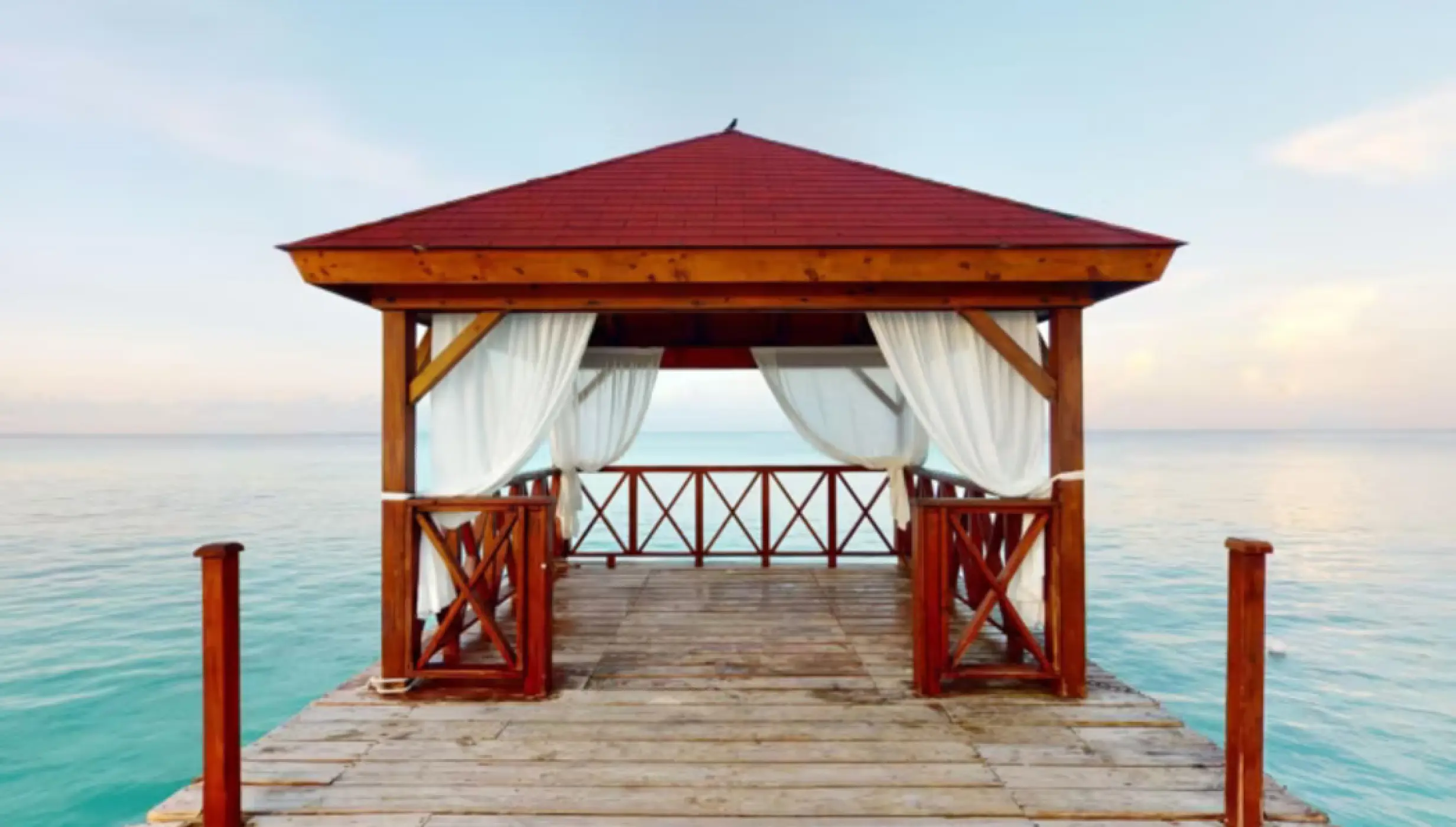 Wooden pier wedding gazebo with white curtains at Iberostar Selection Hacienda Dominicus, La Romana