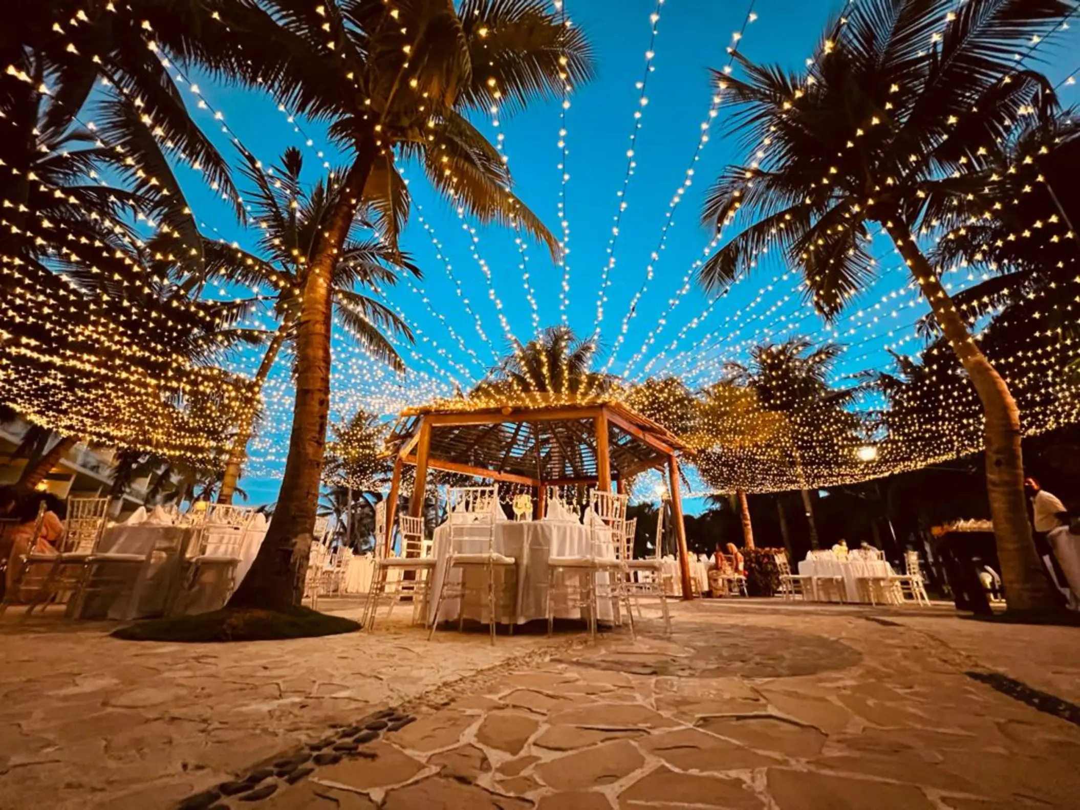 Evening wedding reception under canopy lights and palm trees at Iberostar Selection Riviera Cancun, Cancun