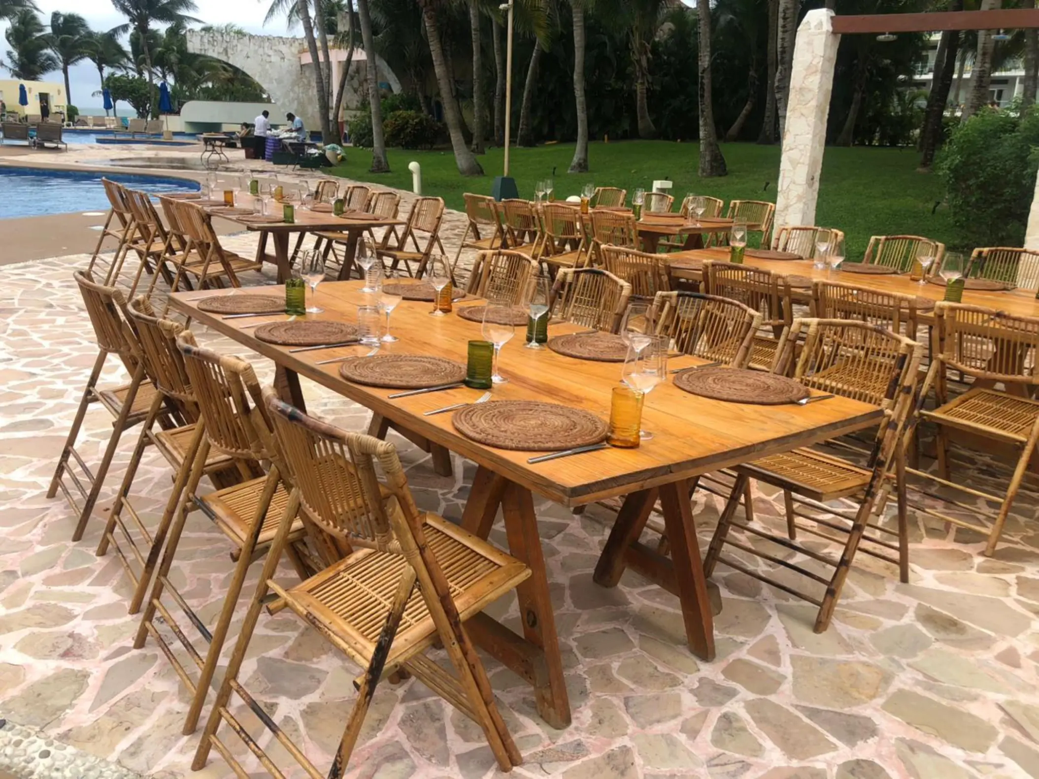 Outdoor wedding reception setup with wooden tables and bamboo chairs at Iberostar Selection Riviera Cancun, Cancun