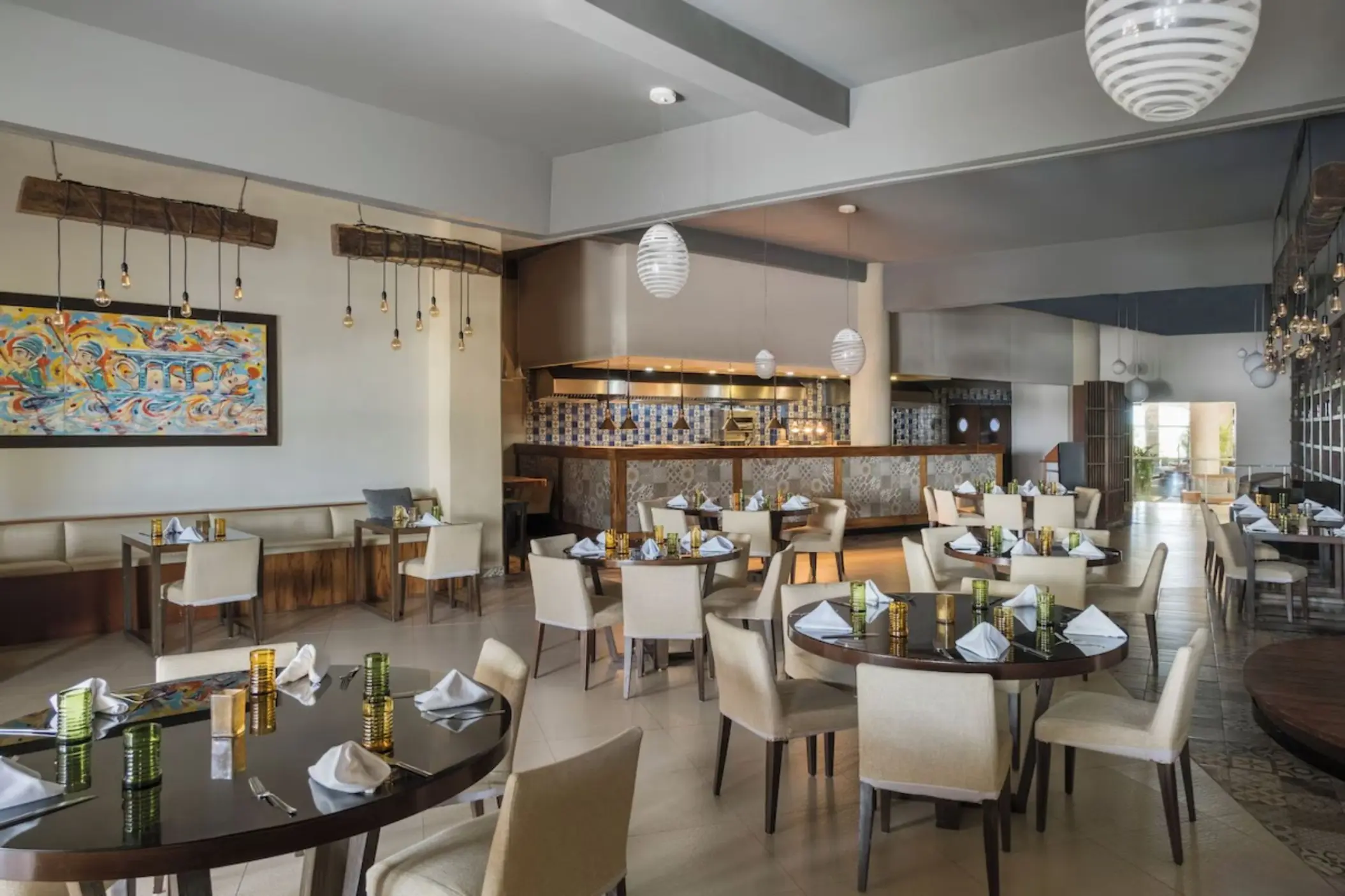 Modern indoor restaurant with set round tables and bar area at Iberostar Selection Riviera Cancun, Cancun