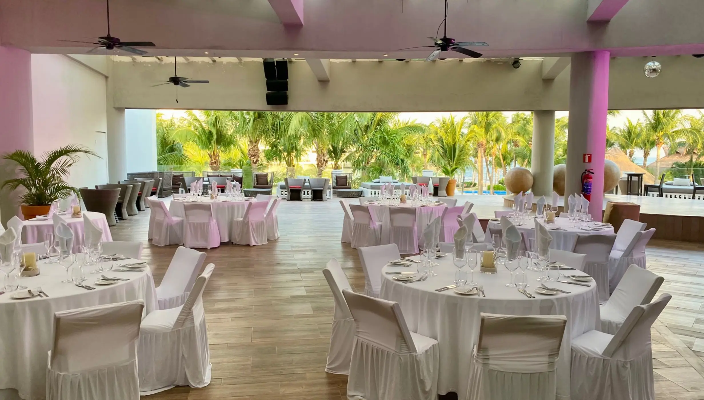 Covered roof garden wedding reception with white round tables at Iberostar Selection Riviera Cancun