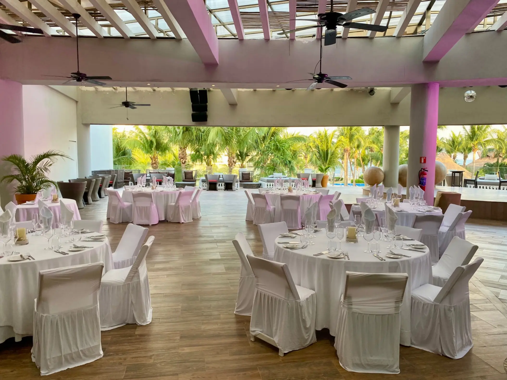 Covered roof garden wedding reception with white round tables at Iberostar Selection Riviera Cancun