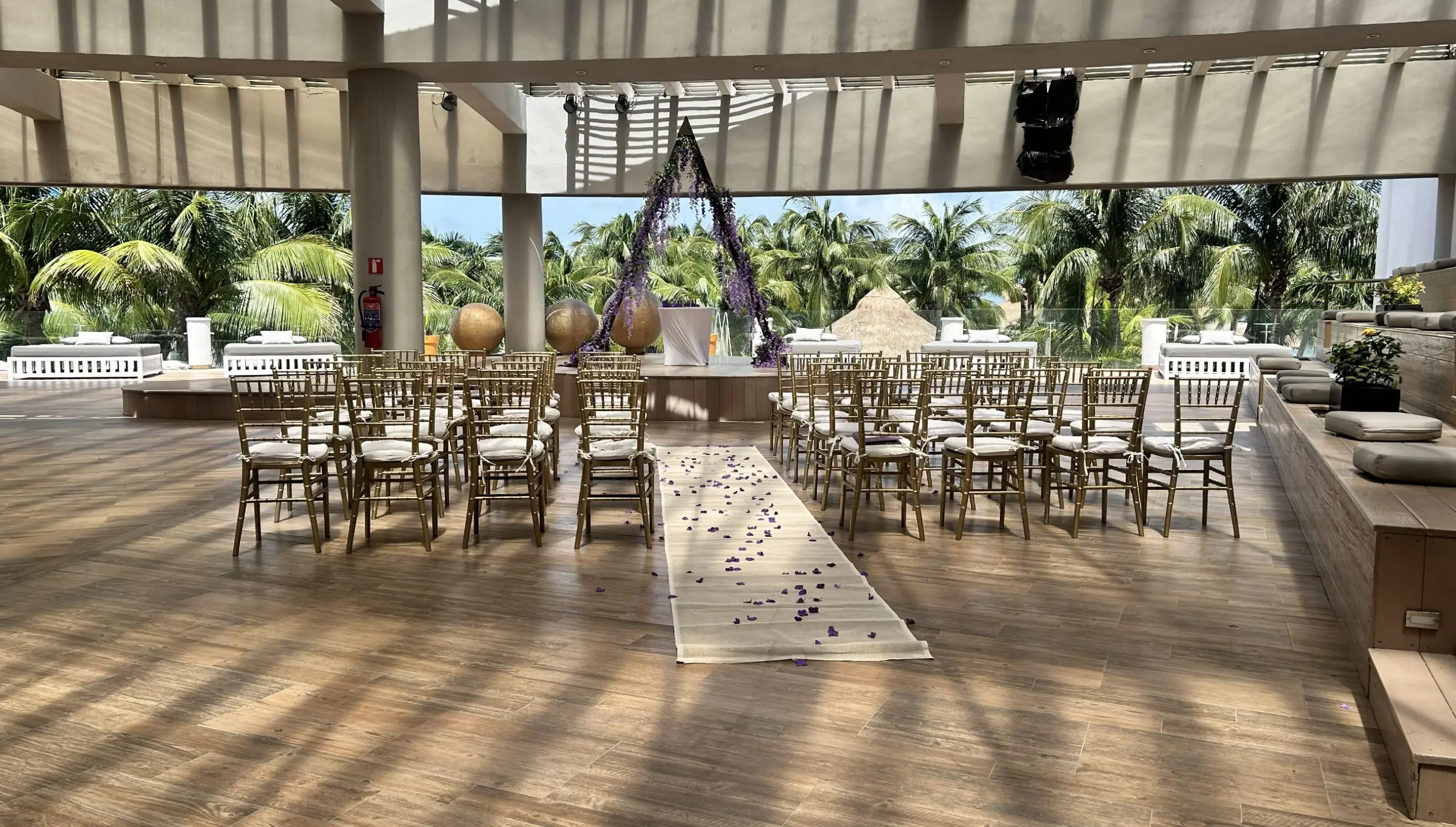 Roof garden wedding ceremony venue with a floral triangle arch at Iberostar Selection Riviera Cancun