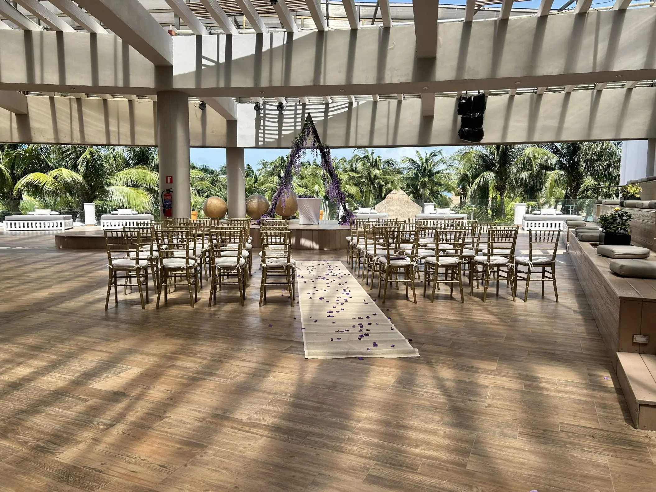 Roof garden wedding ceremony venue with a floral triangle arch at Iberostar Selection Riviera Cancun