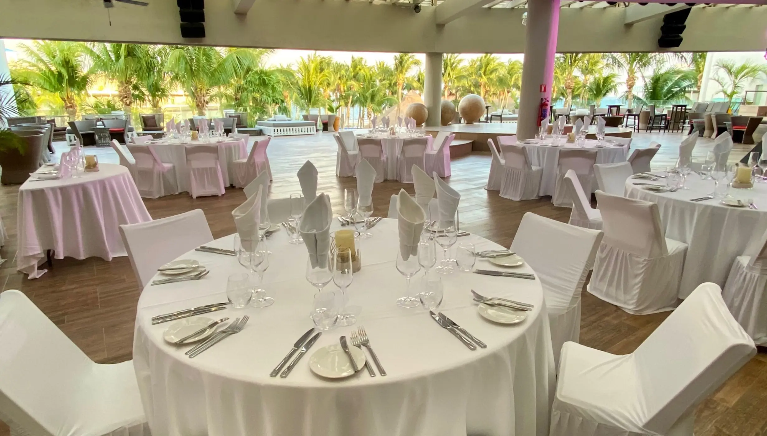 Sheltered roof garden wedding reception with white table settings at Iberostar Selection Riviera Cancun, Cancun