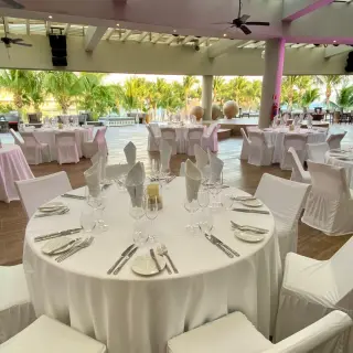 Sheltered roof garden wedding reception with white table settings at Iberostar Selection Riviera Cancun, Cancun