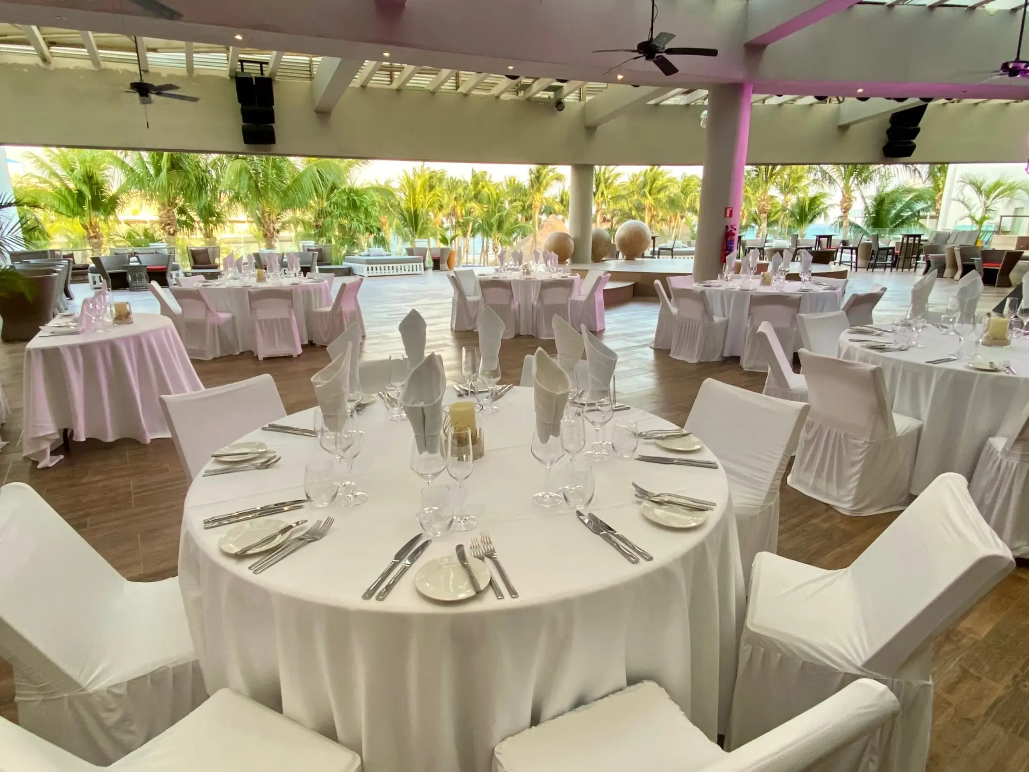 Sheltered roof garden wedding reception with white table settings at Iberostar Selection Riviera Cancun, Cancun