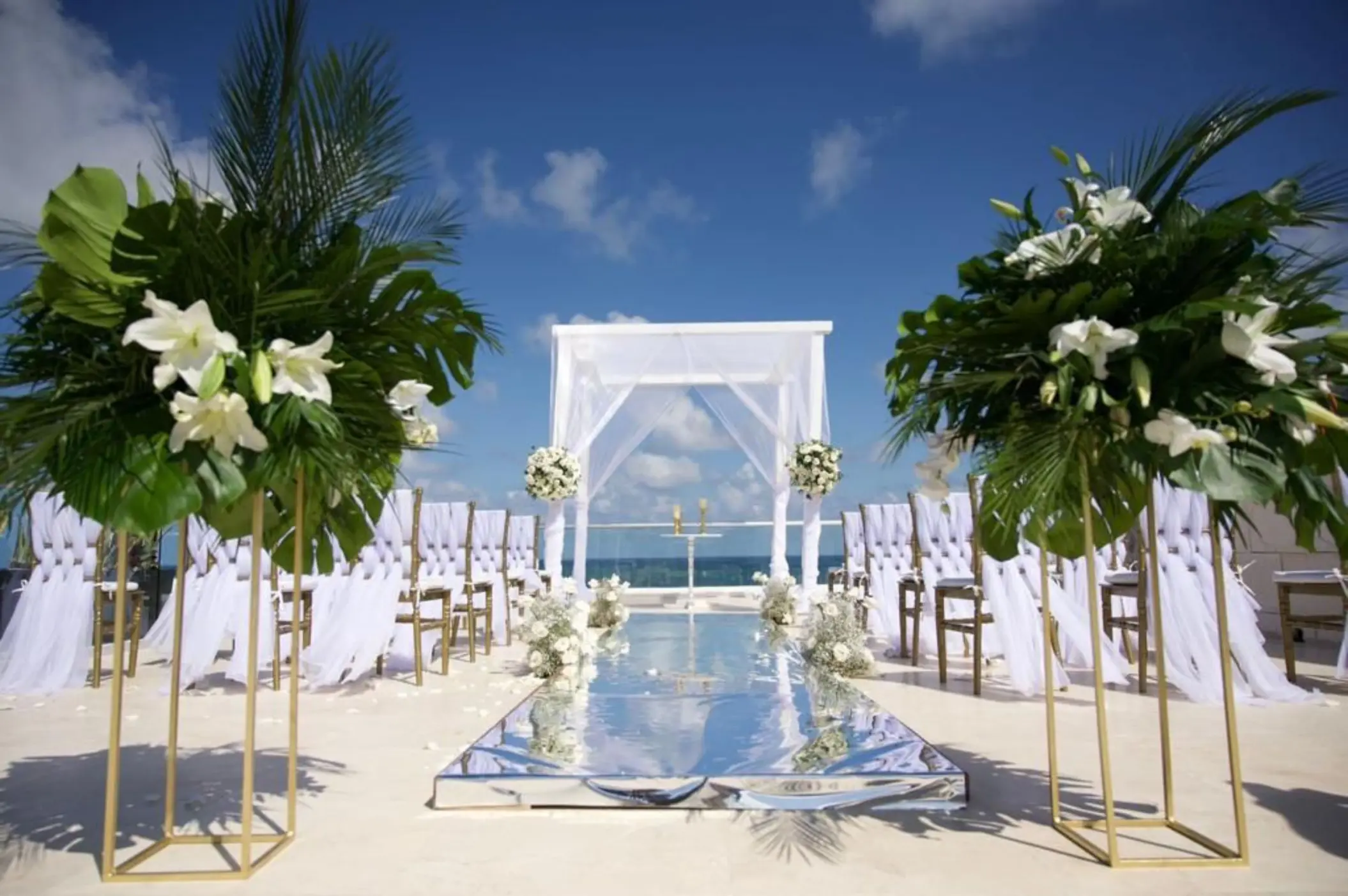 Rooftop wedding ceremony with white huppah and mirrored aisle at Iberostar Selection Riviera Cancun