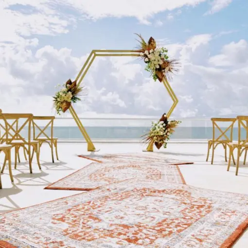 Hexagonal arch and wooden chairs for a rooftop wedding ceremony at Iberostar Selection Riviera Cancun