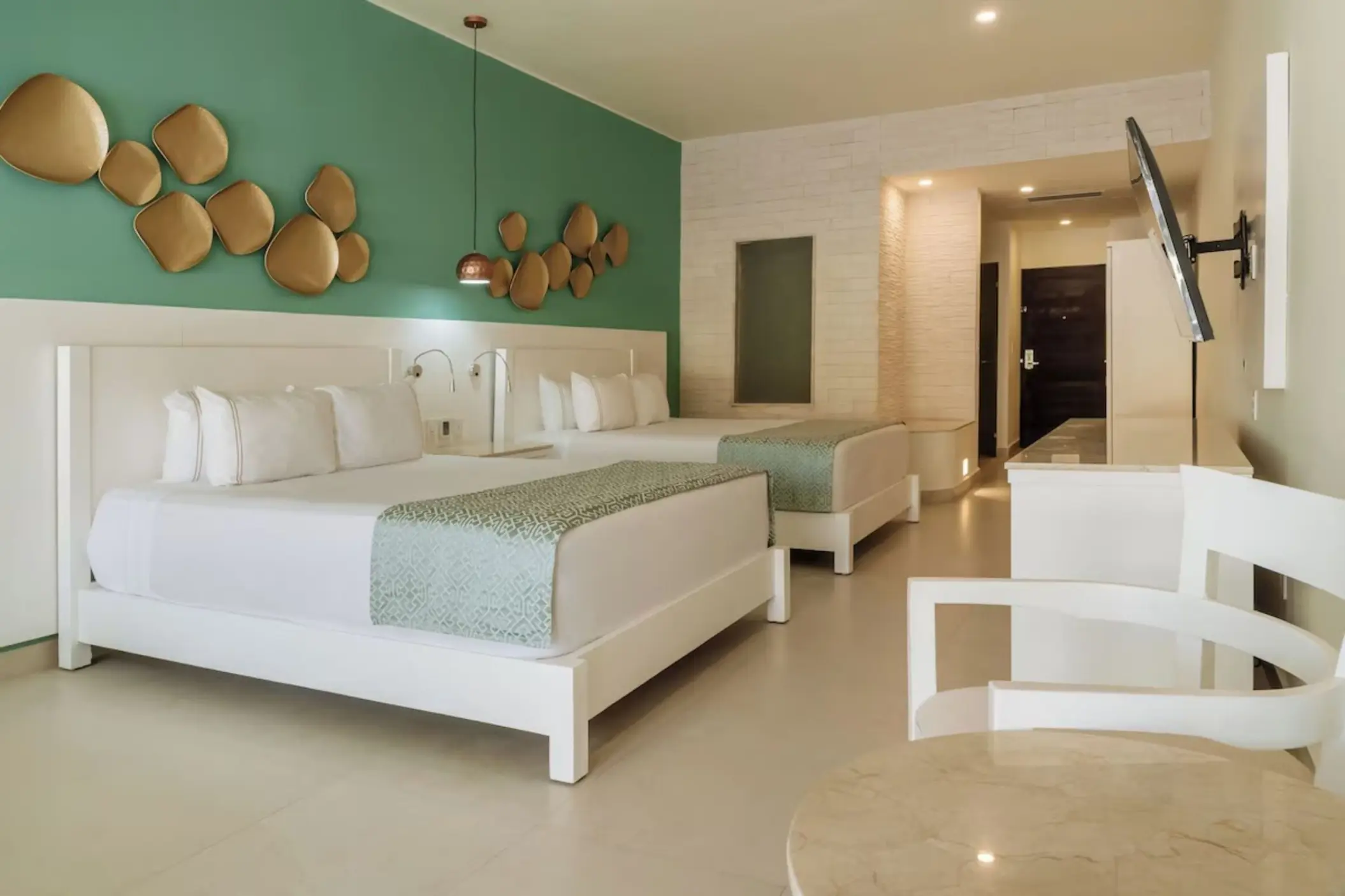 Suite with two double beds and green accent wall at Iberostar Selection Riviera Cancun