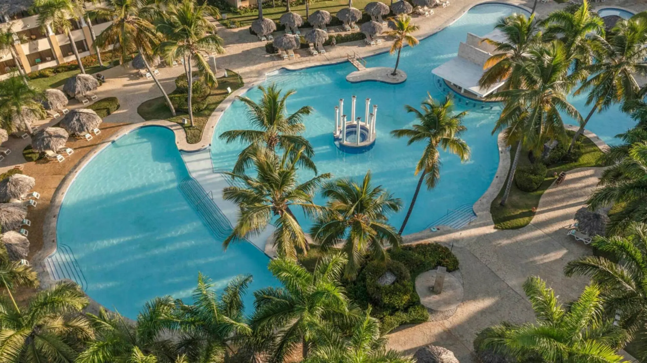 Aerial view of the large lagoon swimming pool surrounded by palm trees at Iberostar Costa Dorada, Puerto Plata