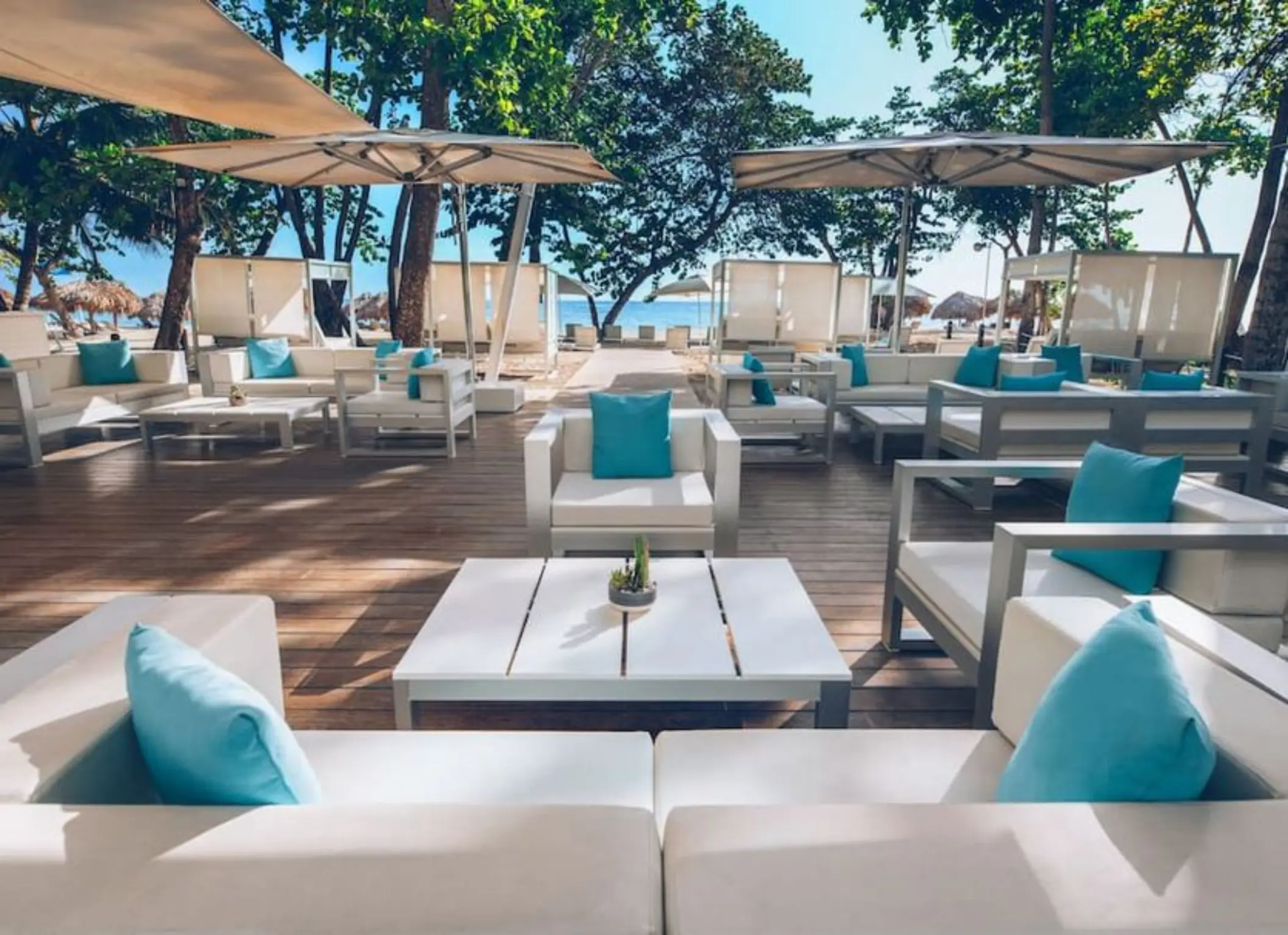 Beachside lounge with white sofas and turquoise pillows at Iberostar Waves Costa Dorada, Puerto Plata