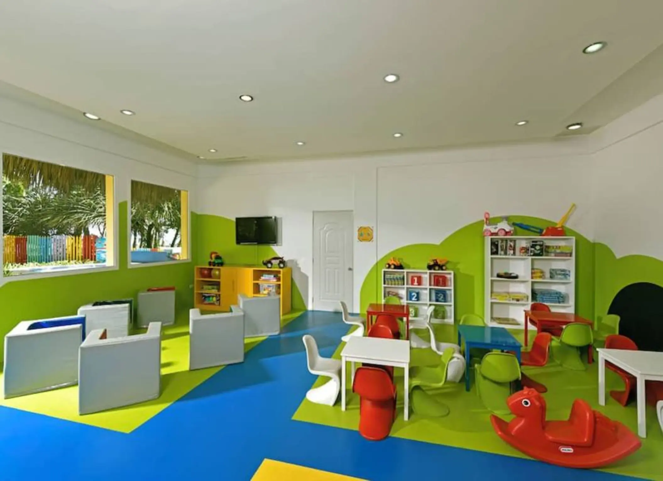 Colorful indoor kids club with small tables and chairs at Iberostar Waves Costa Dorada, Puerto Plata