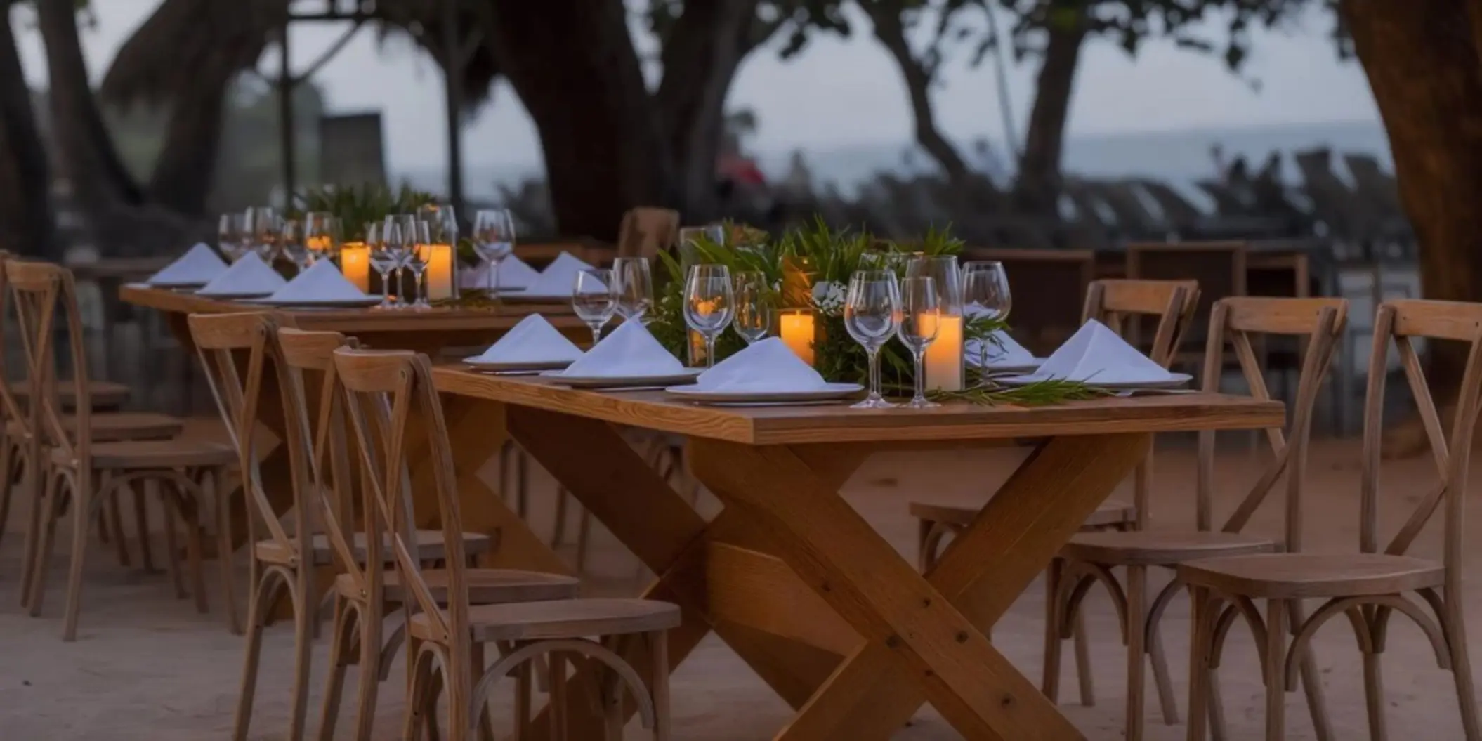 Outdoor wedding reception setup with wooden tables and candles at Iberostar Waves Costa Dorada, Puerto Plata