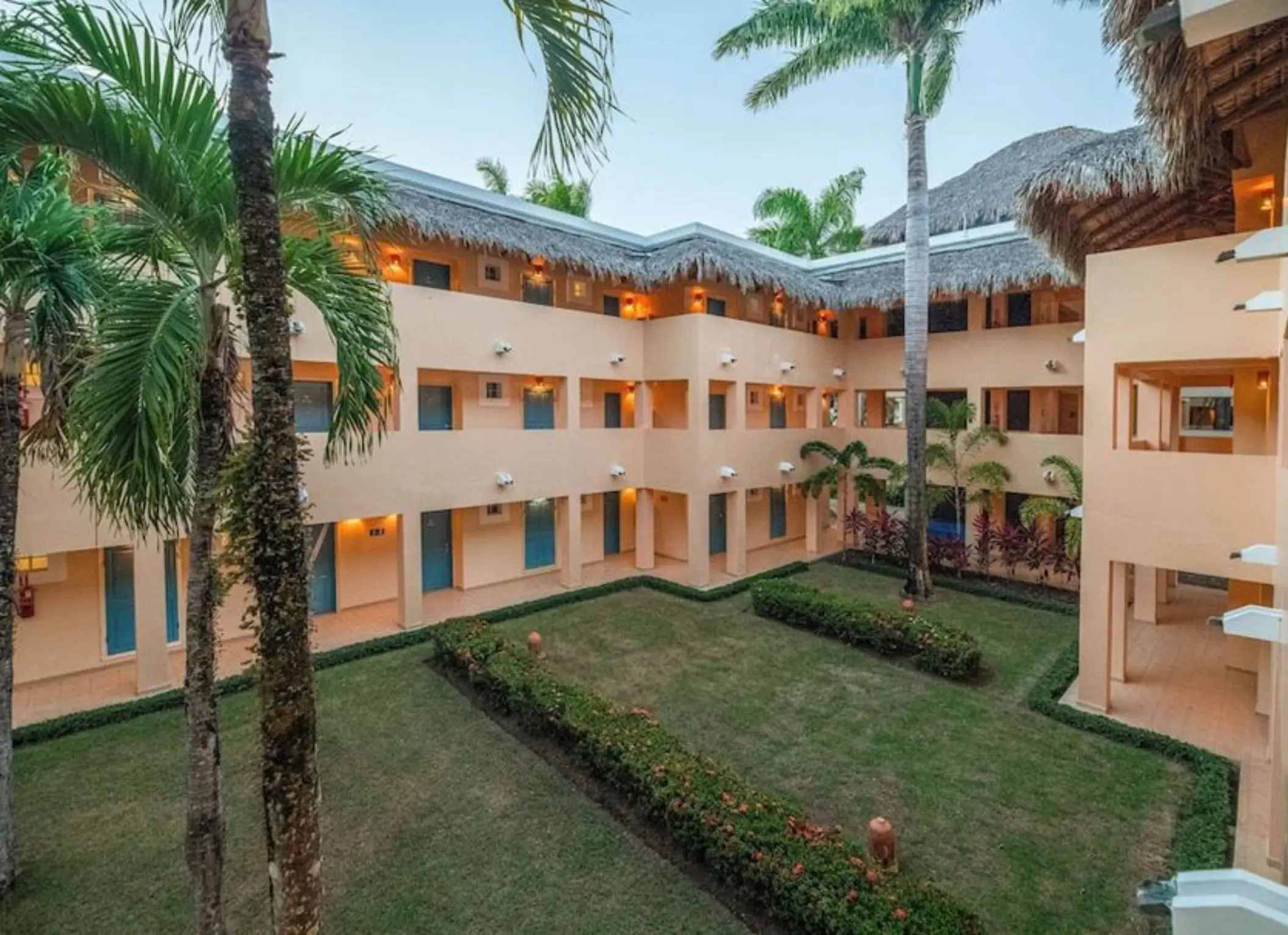 Tropical courtyard and palm trees surrounded by guest room balconies at Iberostar Costa Dorada, Puerto Plata