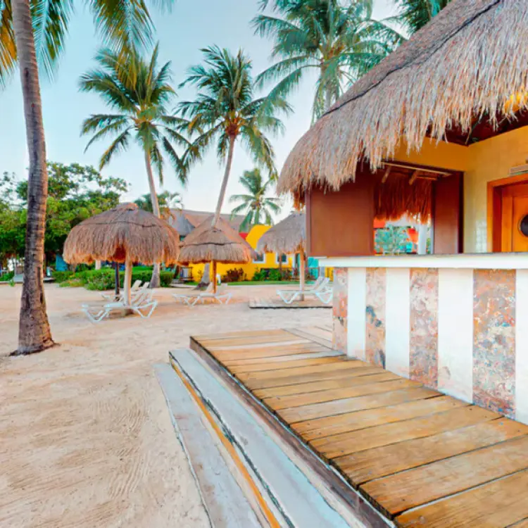 Thatched-roof beach bar and lounge area at Iberostar Waves Cozumel