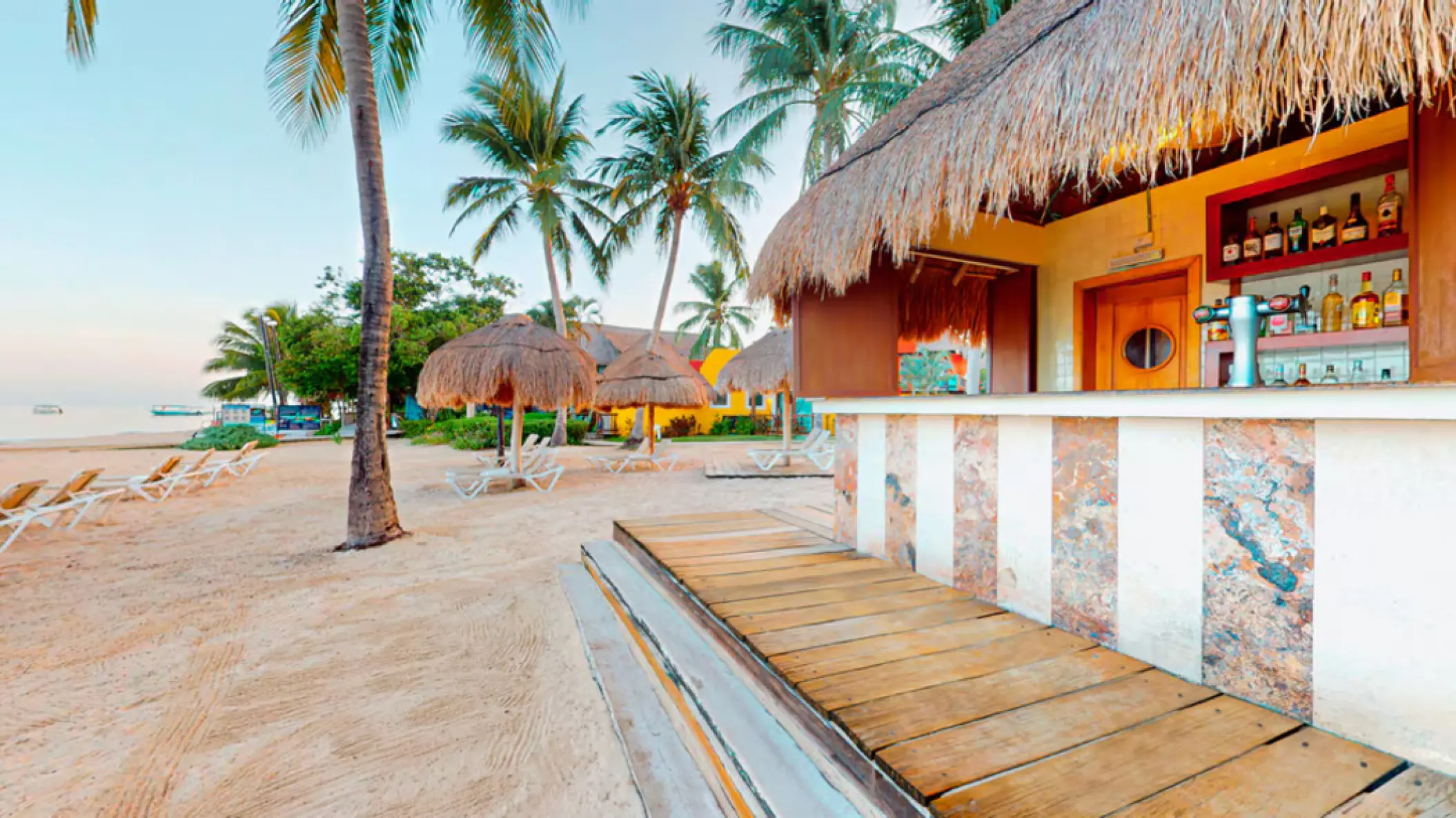 Thatched-roof beach bar and lounge area at Iberostar Waves Cozumel