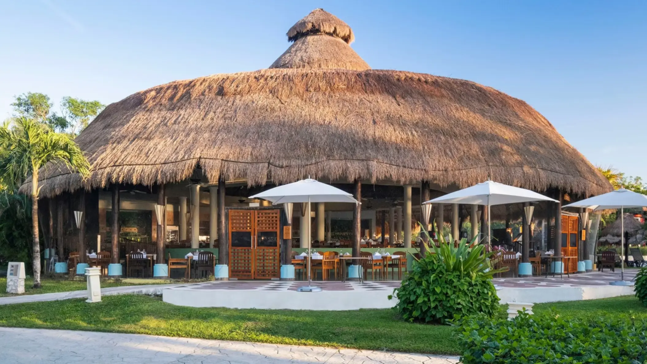 Thatched-roof palapa restaurant with outdoor seating at Iberostar Waves Cozumel