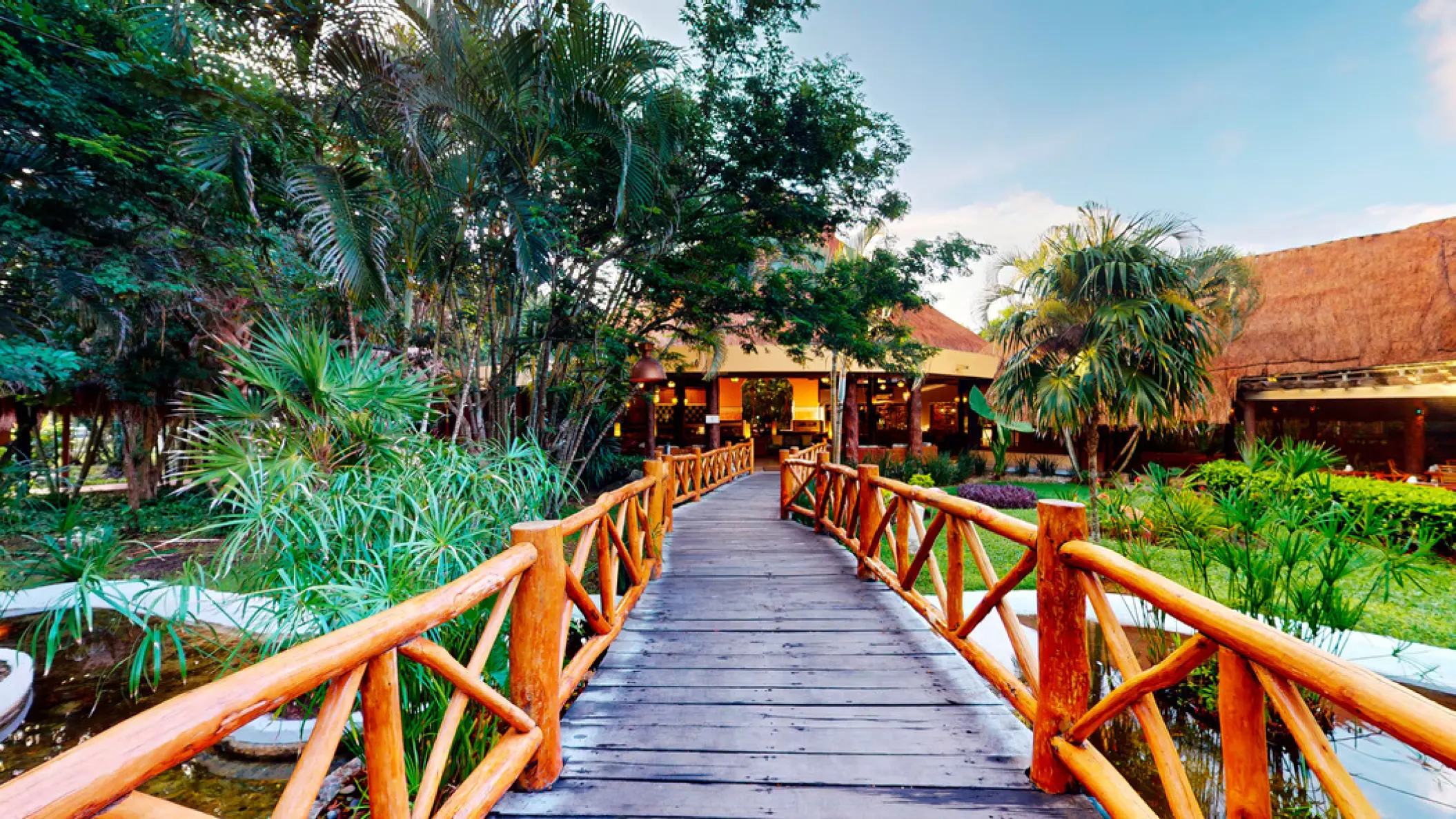 Wooden walkway through tropical gardens and ponds at Iberostar Waves Cozumel