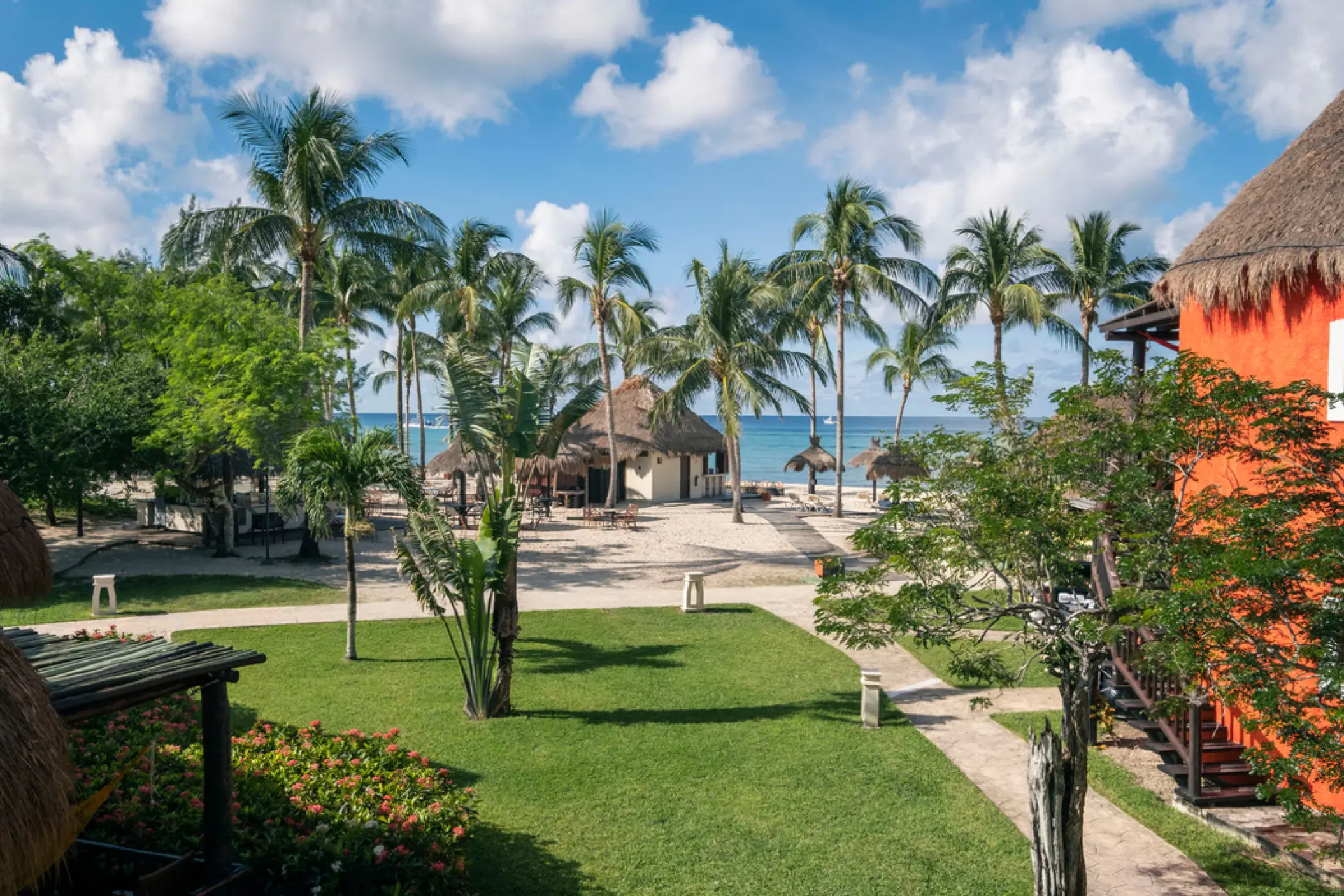 Landscaped gardens and palm trees leading to the beach at Iberostar Waves Cozumel