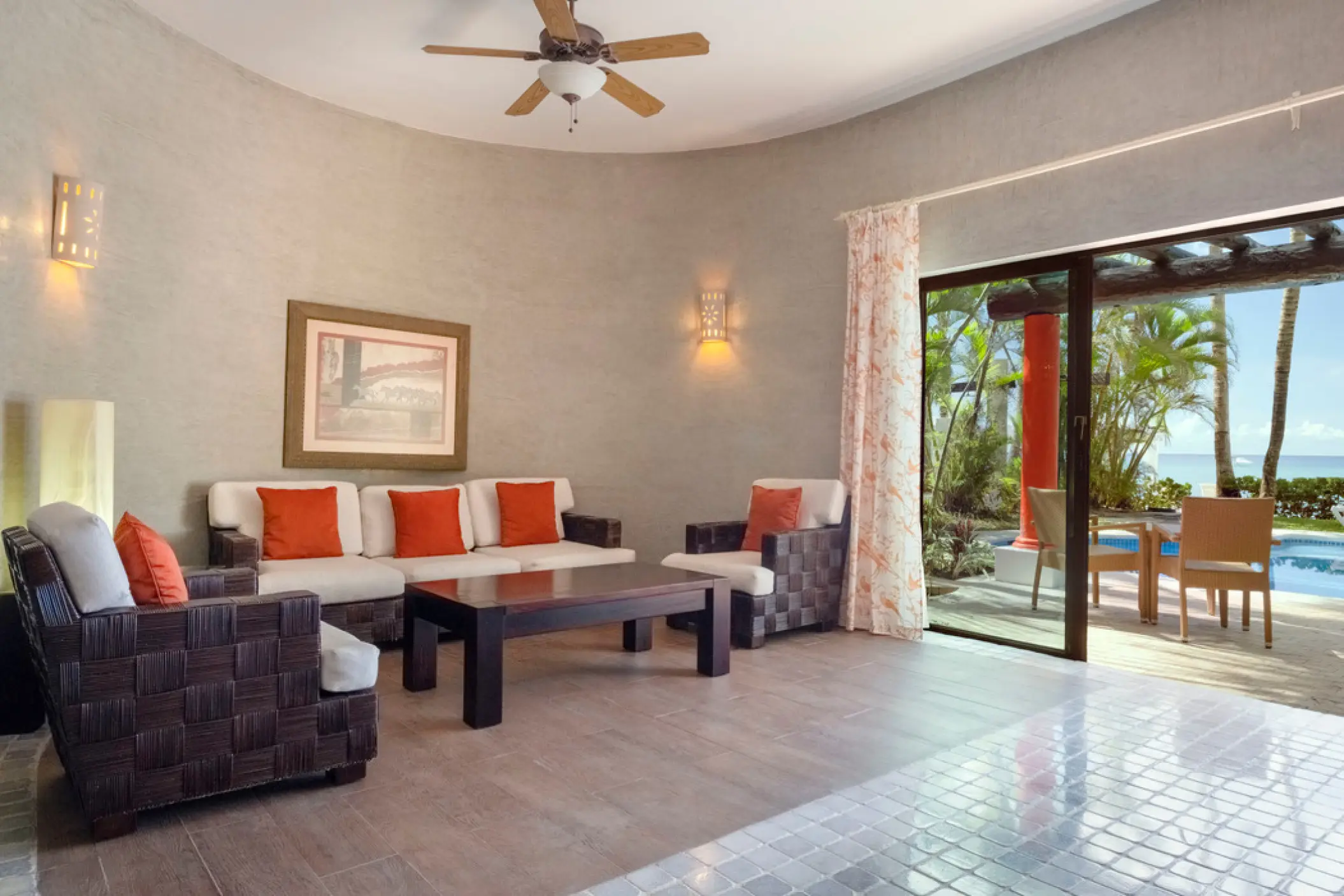 Oceanfront suite living room opening to a patio at Iberostar Cozumel
