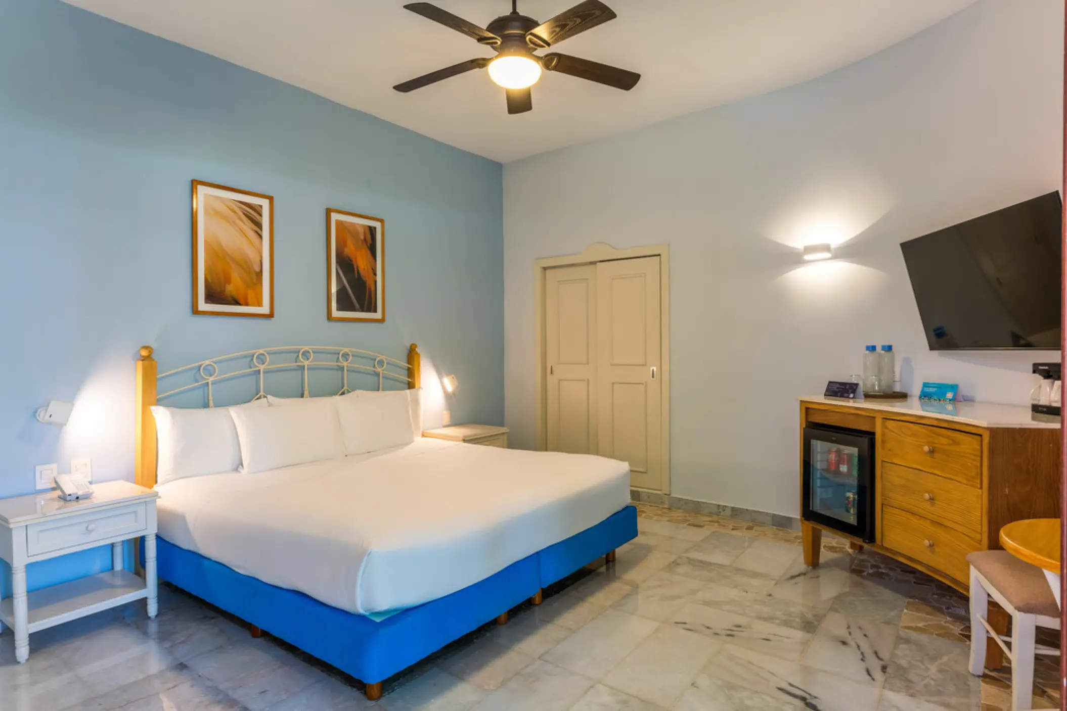Guest room with white linens and light blue walls at Iberostar Waves Cozumel