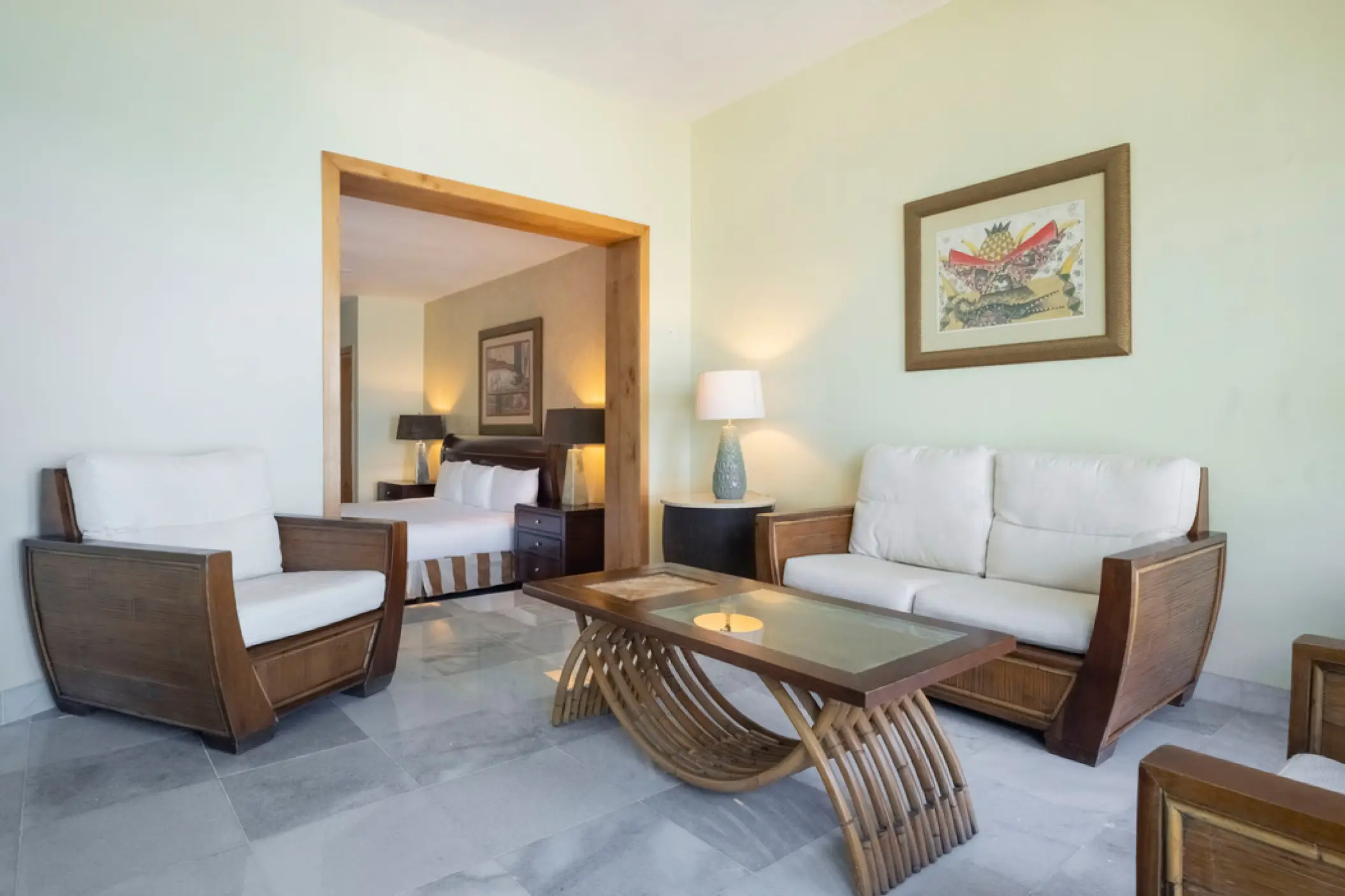 Iberostar Waves Cozumel suite living area with wood furniture and view of the bedroom, Cozumel