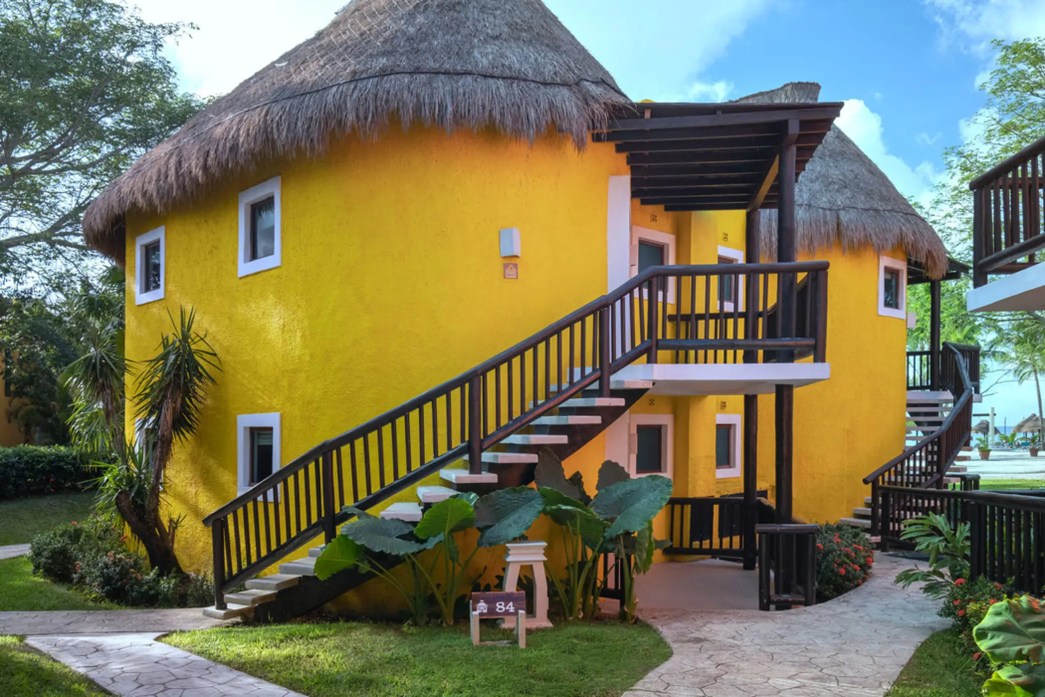 Yellow bungalow-style guest suites with thatched roofs at Iberostar Waves Cozumel, Cozumel