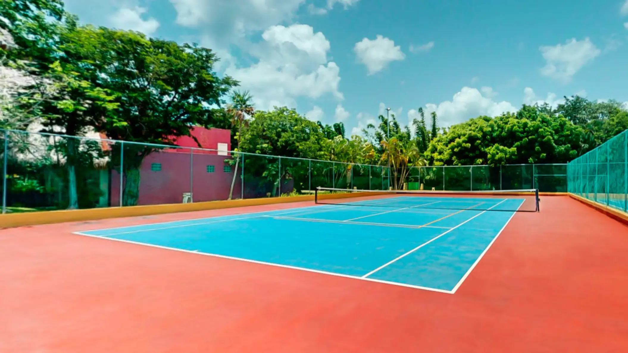 Blue and red outdoor tennis court at Iberostar Waves Cozumel, Cozumel