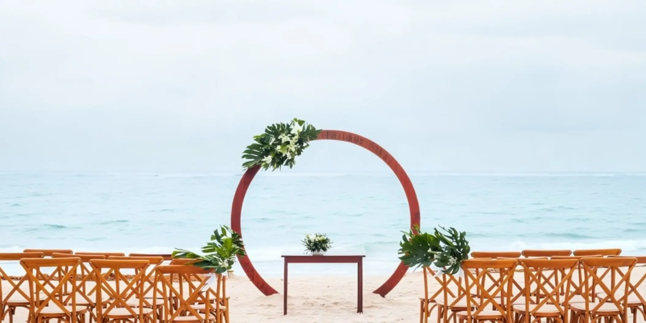 Beachfront wedding ceremony with circular wood arch at Iberostar Waves Dominicana, Punta Cana