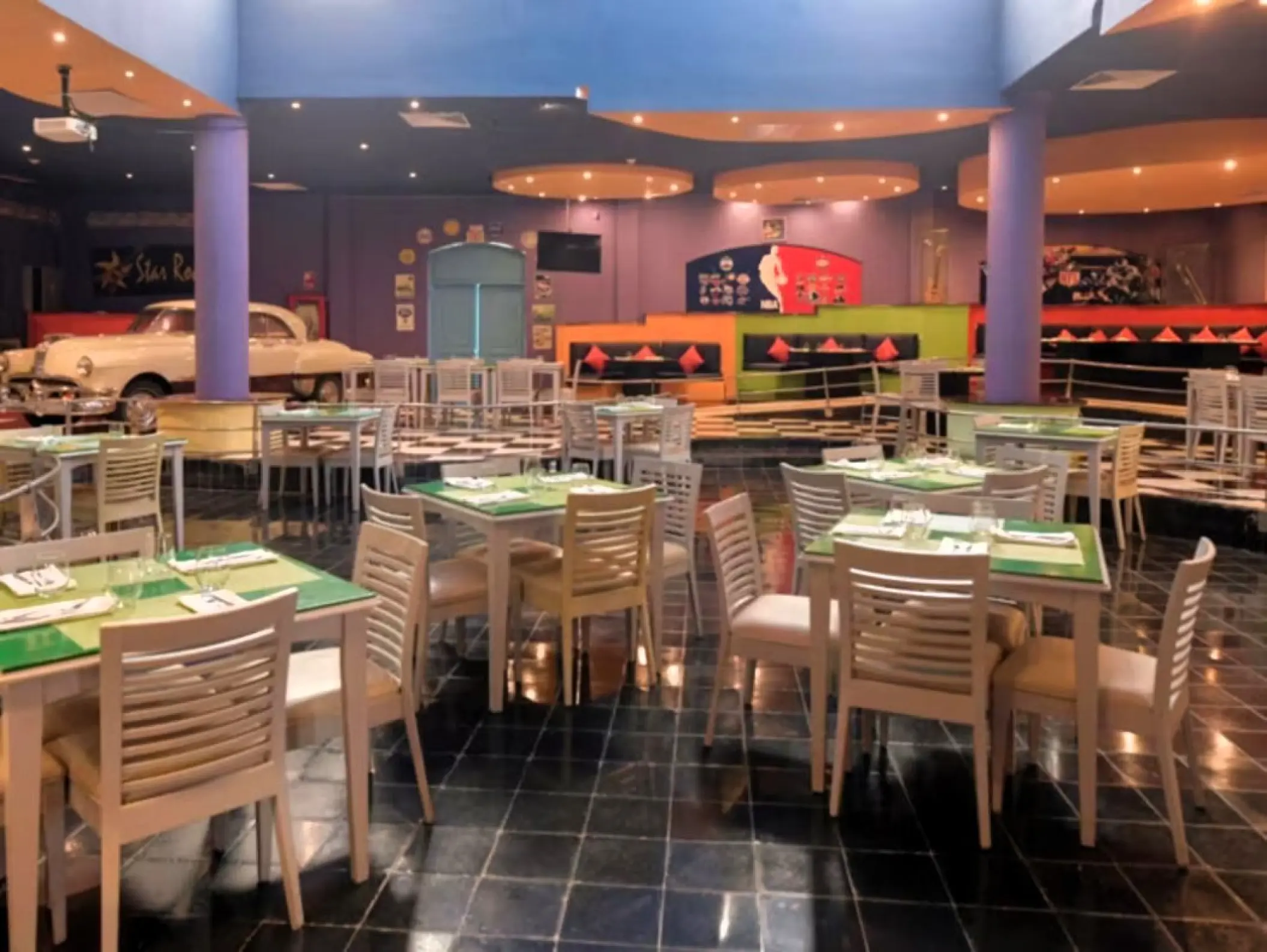 Sports-themed diner with a classic car and checkered floor at Iberostar Waves Dominicana, Punta Cana