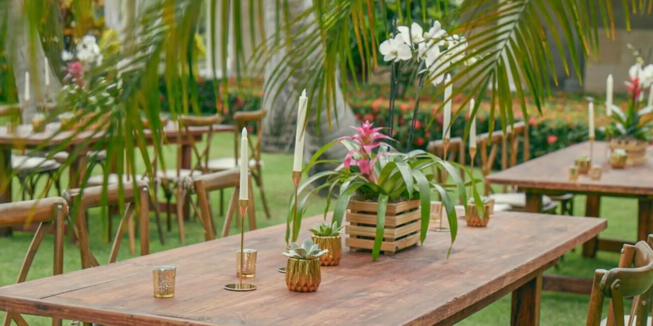 Garden wedding reception tables with tropical floral centerpieces and candles at Iberostar Waves Dominicana, Punta Cana